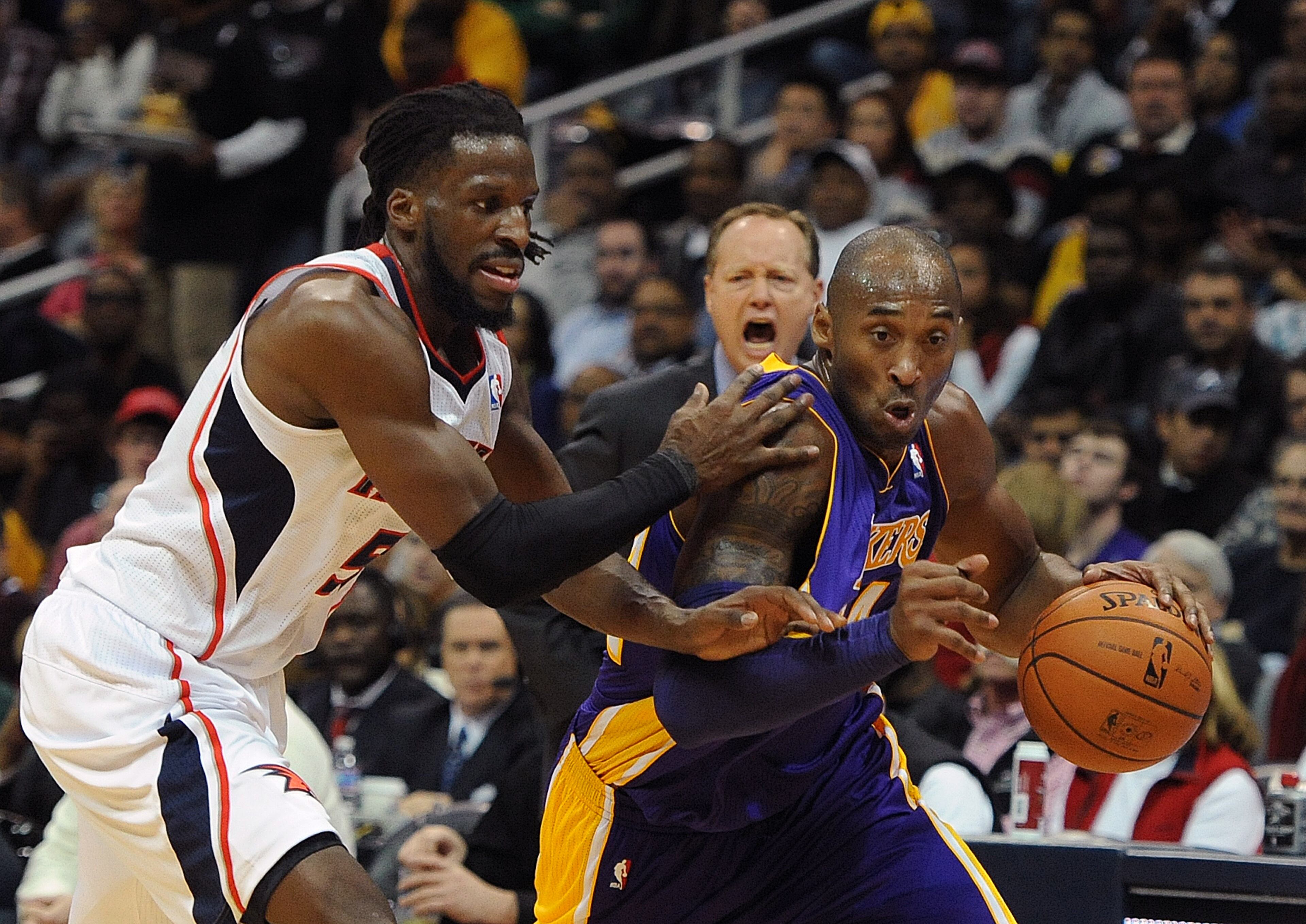 Hawks coach Mike Budenholzer yells instructions as the DeMarre Carroll (left) defends against the Lakers' Kobe Bryant on December 16, 2013. JOHNNY CRAWFORD / JCRAWFORD@AJC.COM