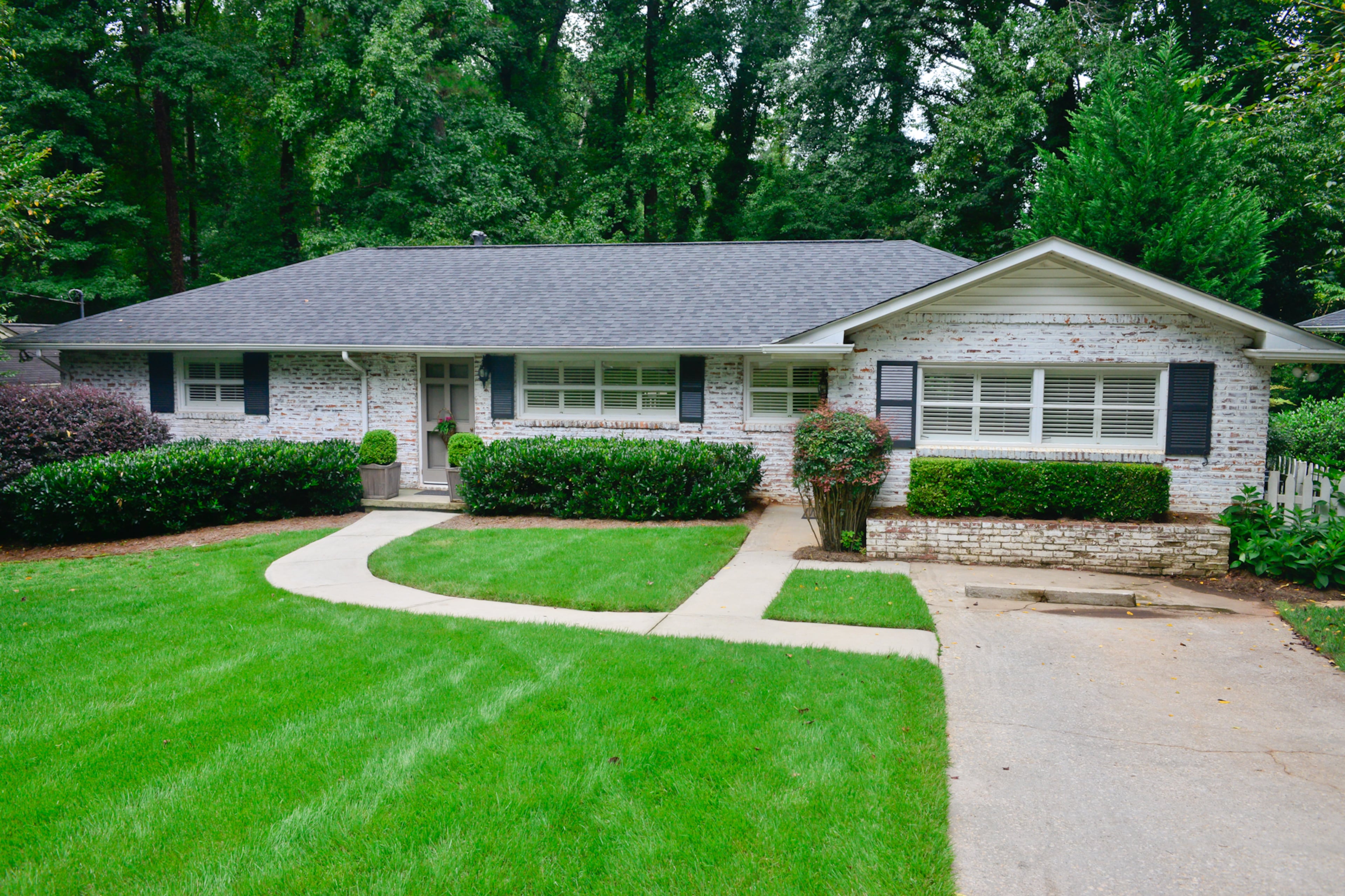 The home's exterior has whitewashed brick. The home had red doors and black shutters, but the couple repainted the door in a warm gray and the shutters in a charcoal gray, Betsy Clay said. Crown molding and canned lighting are two of Clay's favorite elements throughout the home.