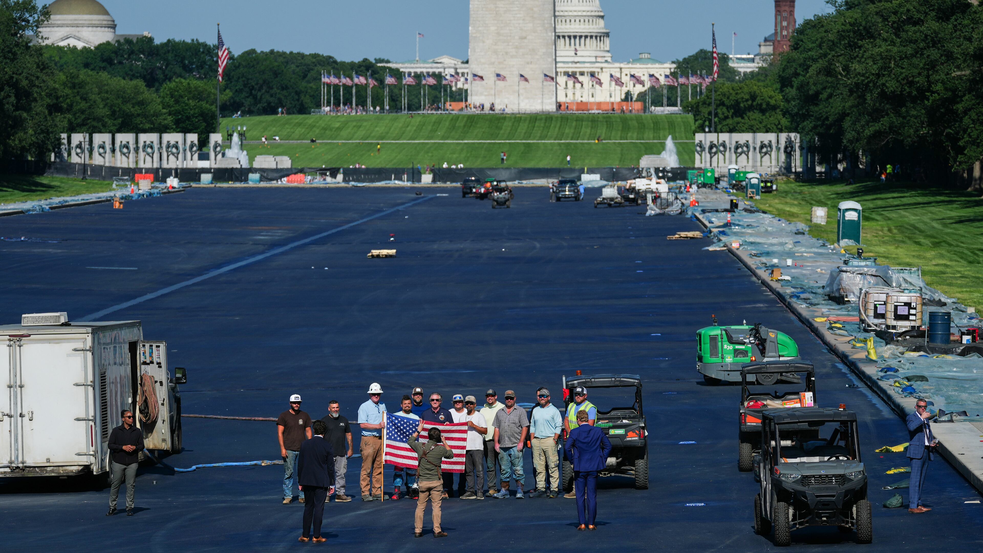 Interior Secretary Doug Burgum, center, poses for a photo with workers while touring the Lincoln Memorial Reflecting Pool after it was coated in a blue swimming pool surface ahead of the United States' 250th anniversary, Wednesday, June 3, 2026, in Washington. (AP Photo/Julia Demaree Nikhinson)