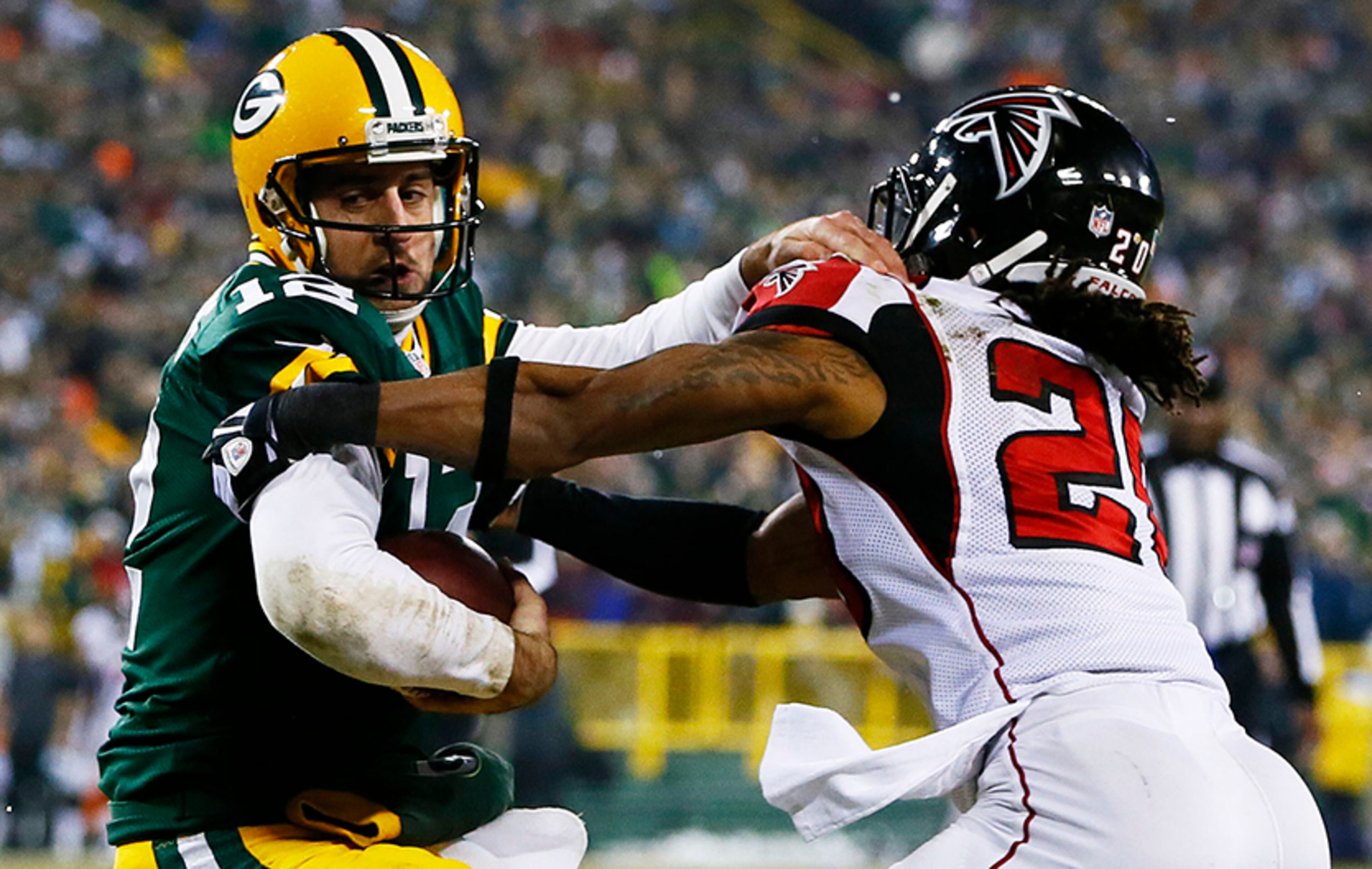 Packers quarterback Aaron Rodgers tries to avoid the tackle of Falcons' Dwight Lowery in the first half at Lambeau Field on Dec. 8, 2014 in Green Bay, Wis.