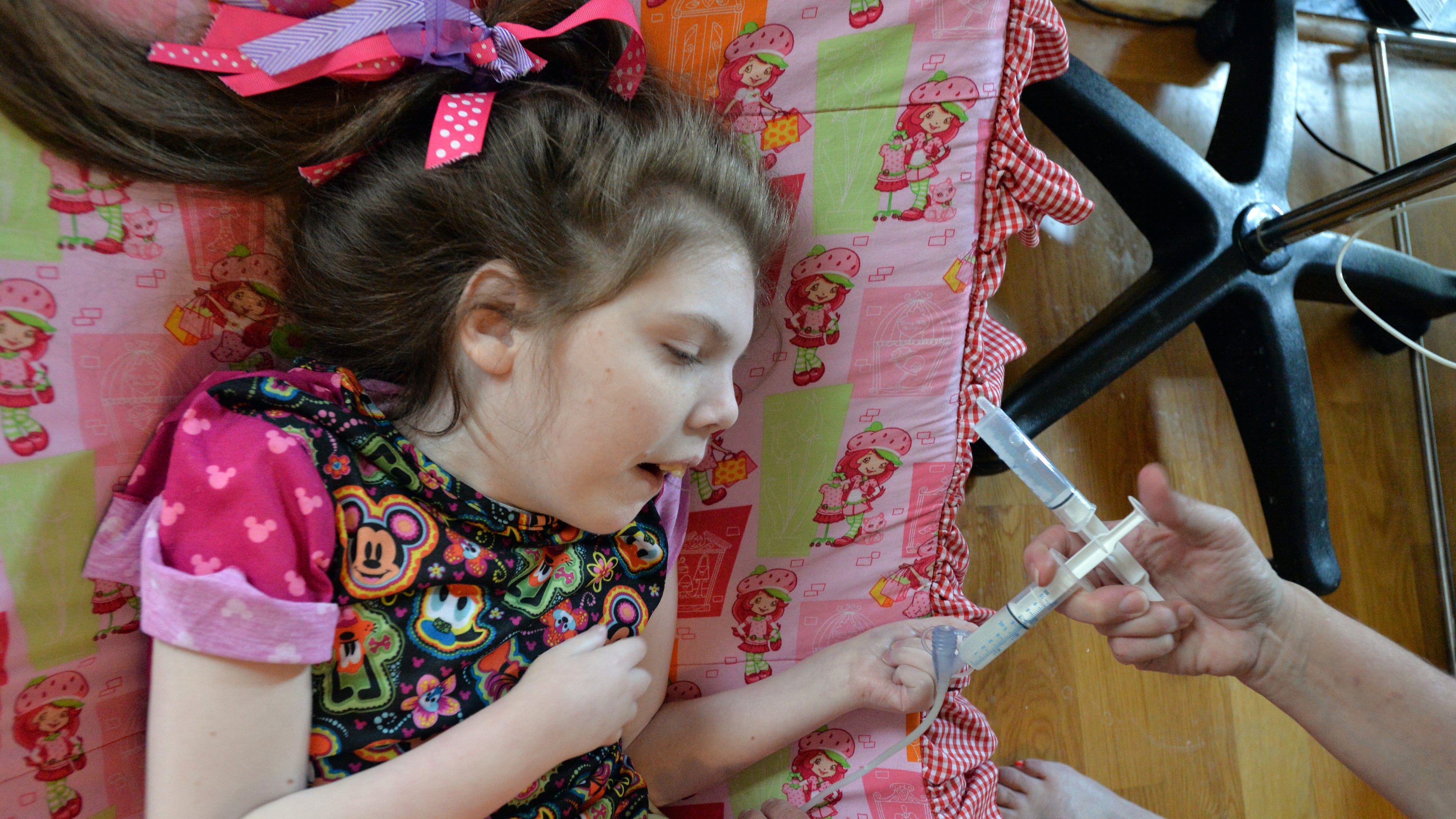 September 9, 2014 Covington - Kelli Hopkins gives medication for her special-needs daughter Mary Elizabeth, 21, at their home in Covington on Tuesday, September 9, 2014. Kelli and Mike Hopkins had three special-needs children who suffer from a seizure disorder that could be treated by a cannabis-based oil (A.K.A. medical marijuana) that is being considered by the Georgia legislature. Their 6-year-old son Abe passed away at the end of July when he had a seizure and stopped breathing. HYOSUB SHIN / HSHIN@AJC.COM