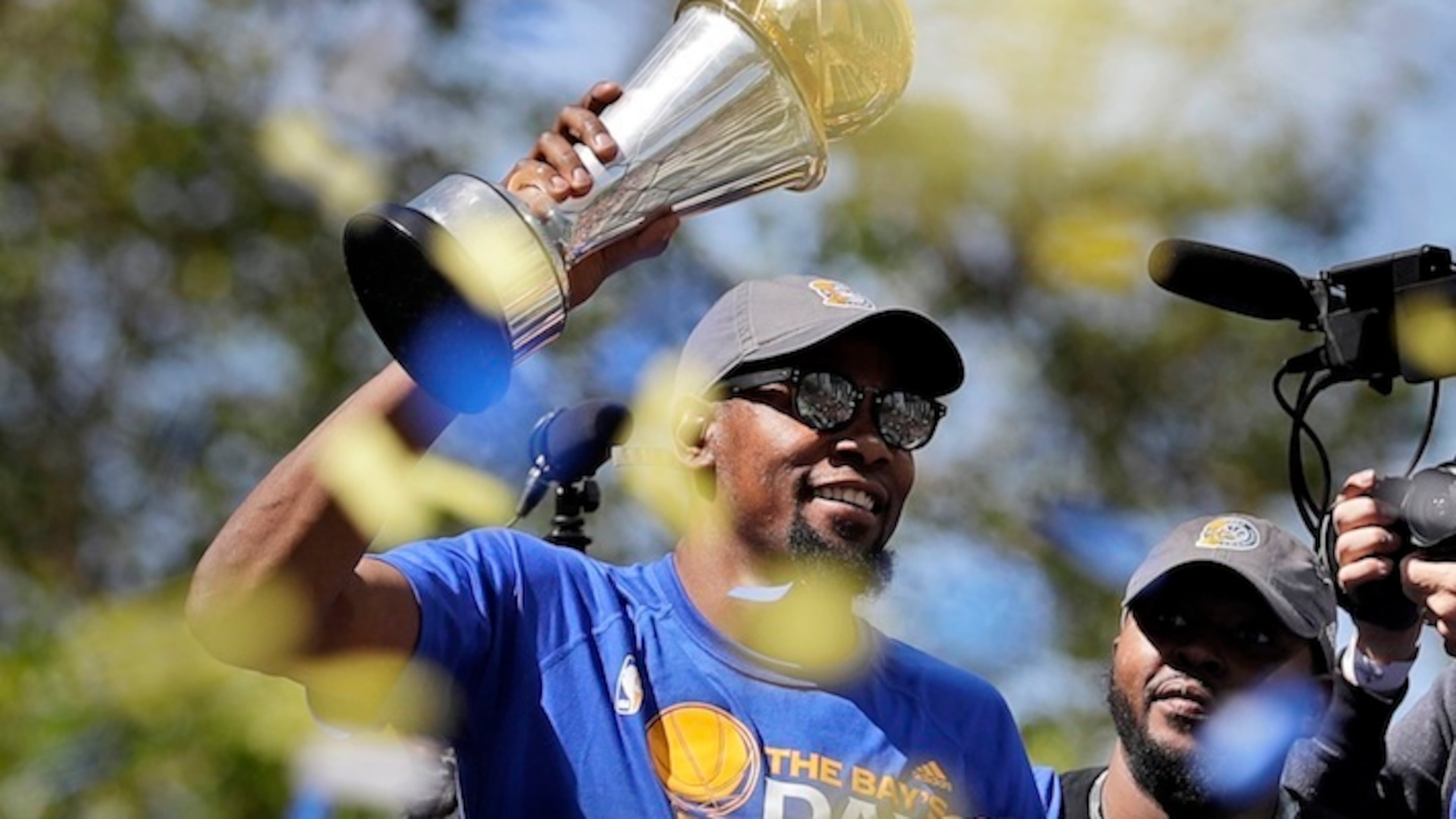 Golden State Warriors' Kevin Durant holds the NBA Finals MVP trophy during a parade and rally after winning the NBA basketball championship Thursday, June 15, 2017, in Oakland, Calif. (AP Photo/Marcio Jose Sanchez)