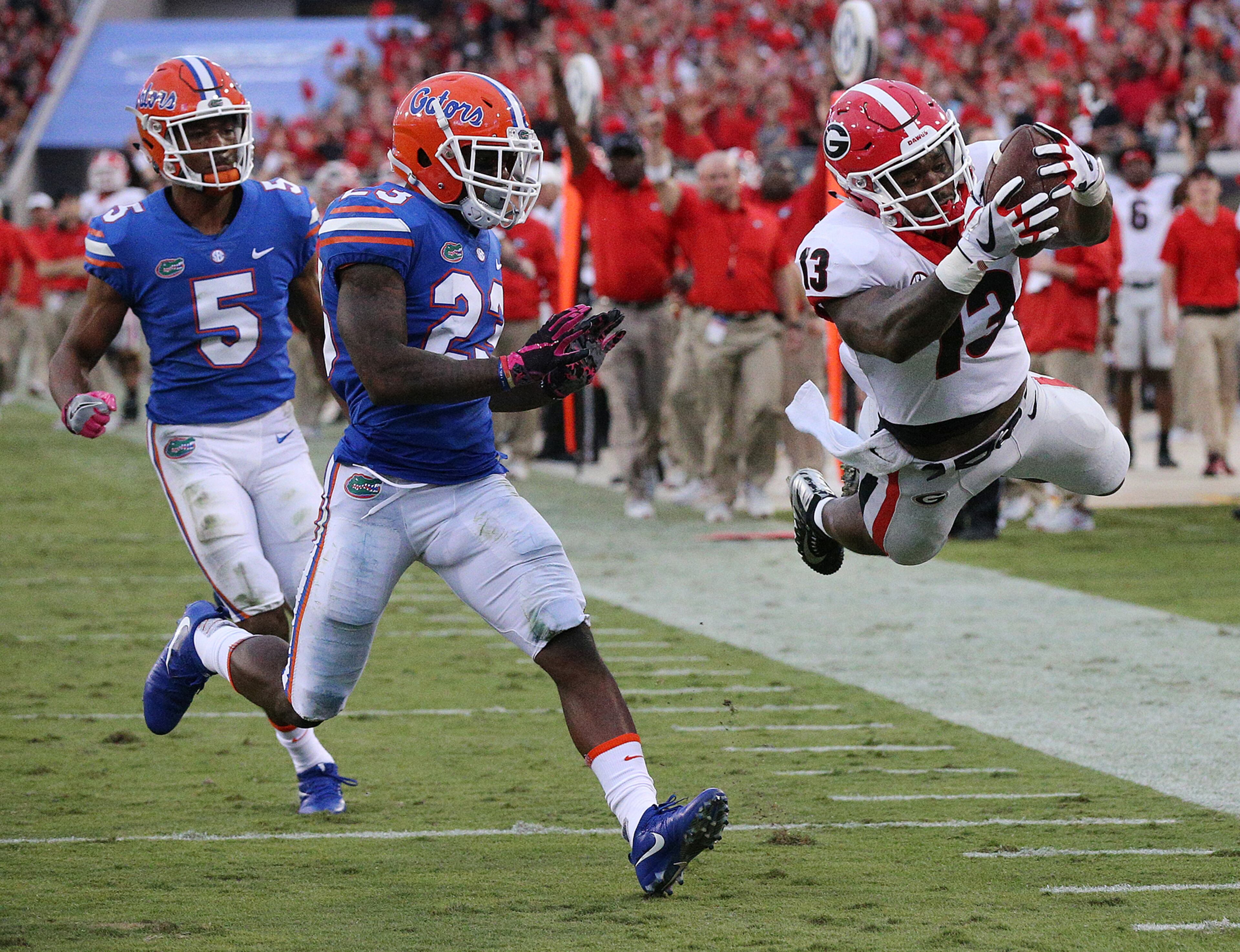 October 28, 2017 Jacksonville: Georgia tailback Elijah Holyfield soars into the endzone past Florida defenders C.J. Henderson and Chauncey Gardner Jr. to take a 42-0 leading during the fourth quarter in the Georgia-Florida NCAA college football game on Friday, October 27, 2017, in Jacksonville. Georgia beat Florida 42-7. Curtis Compton/ccompton@ajc.com