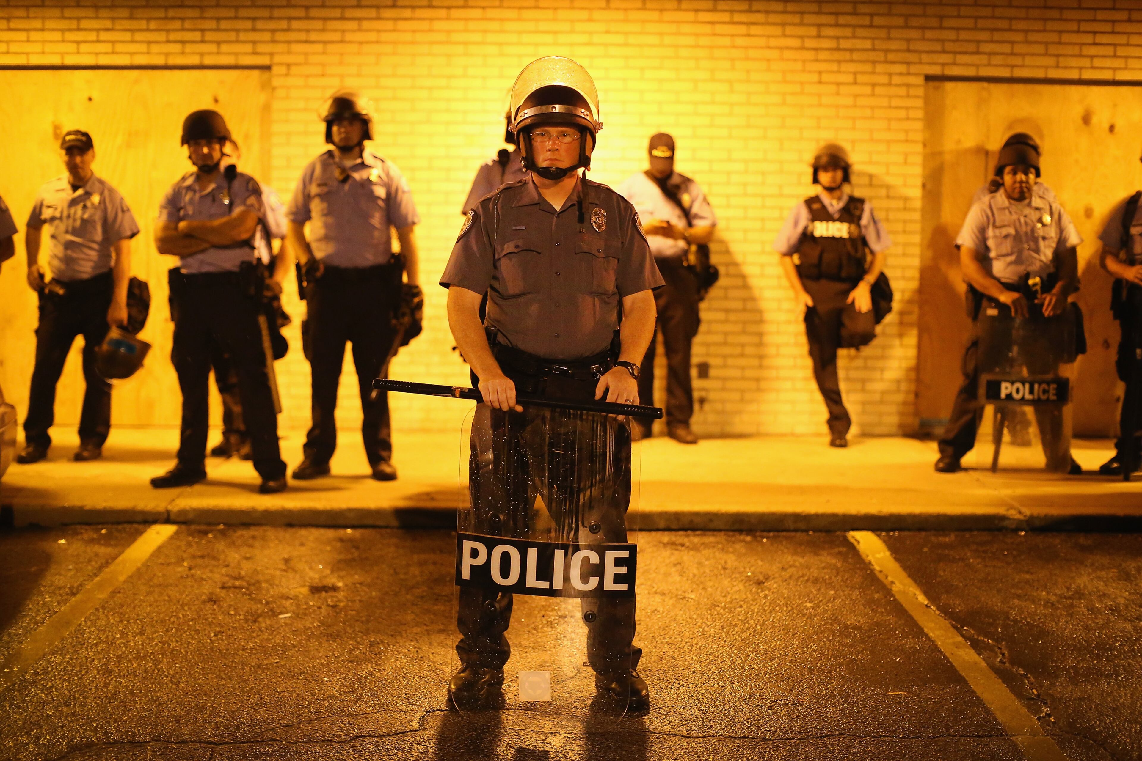 FERGUSON, MO - AUGUST 16: Police stand guard before the mandatory midnight curfew on August 16, 2014 in Ferguson, Missouri. The curfew was imposed on Saturday in an attempt to reign in the violence that has erupted nearly every night in the suburban St. Louis town since the shooting death of teenager Michael Brown by a Ferguson police officer on August 9. (Photo by Scott Olson/Getty Images)
