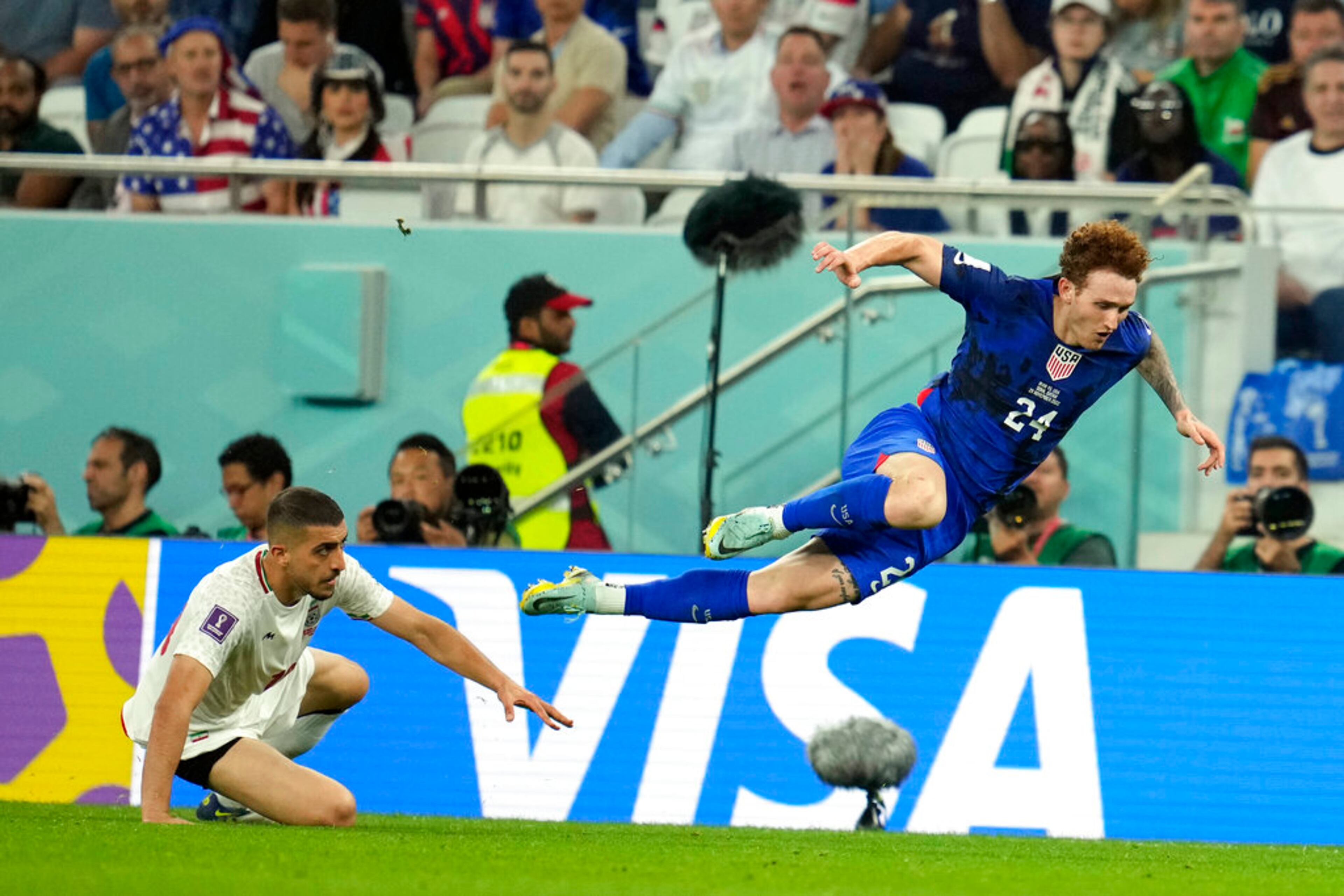 United States' Josh Sargent (24) is upended by Iran's Majid Hosseini during the World Cup group B soccer match between Iran and the United States at the Al Thumama Stadium in Doha, Qatar, Tuesday, Nov. 29, 2022. (AP Photo/Ashley Landis)