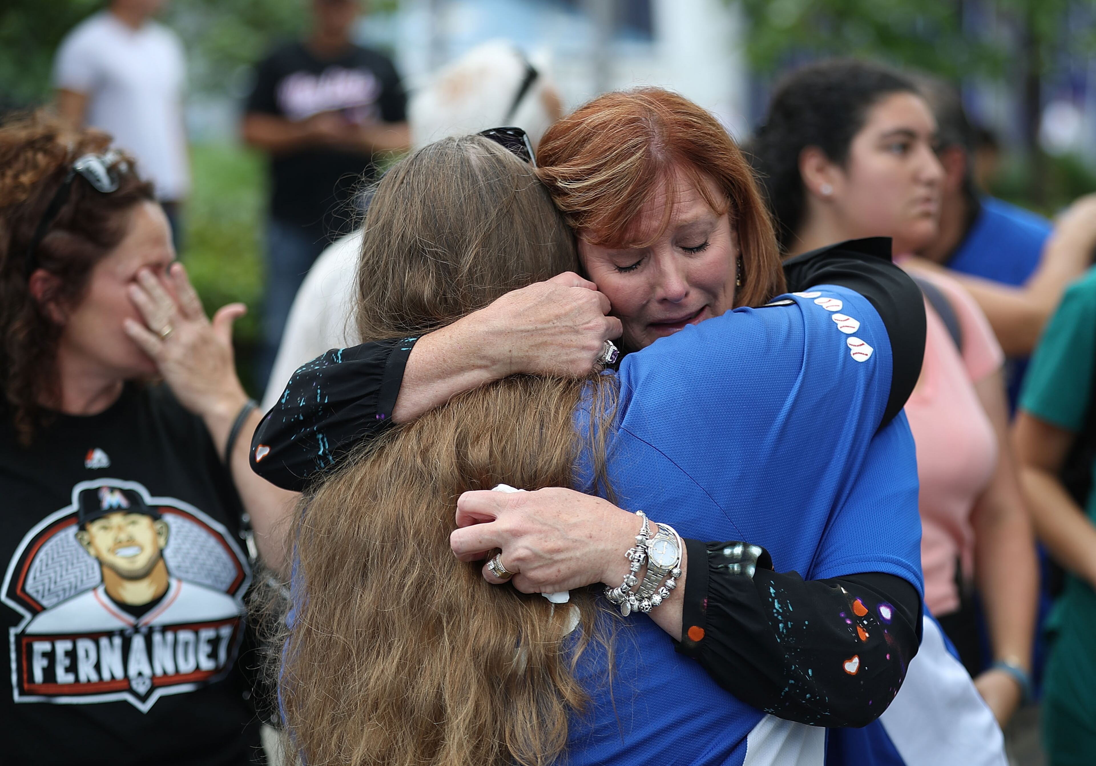 People react after watching the hearse carrying Miami Marlins pitcher Jose Fernandez pass in front of the Marlins baseball stadium on September 28, 2016 in Miami, Florida. Mr. Fernandez was killed in a weekend boat crash in Miami Beach along with two friends. (Photo by Joe Raedle/Getty Images)