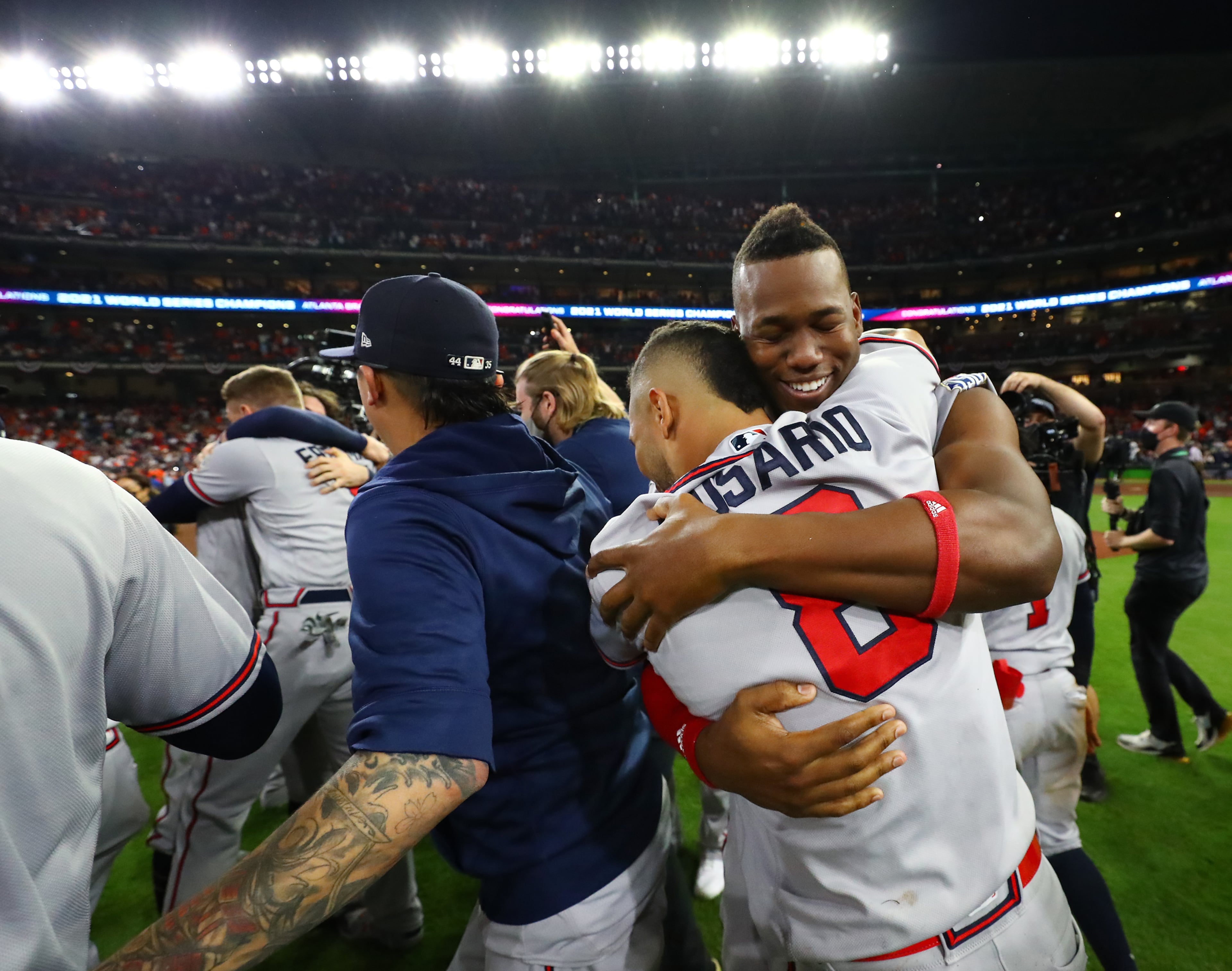 110221 HOUSTON: Braves Jorge Soler (right) hugs Eddie Rosario as players charge the field to celebrate beating the Astros in game 6 to win the World Series on Tuesday, Nov. 2, 2021, in Houston. “Curtis Compton / Curtis.Compton@ajc.com”