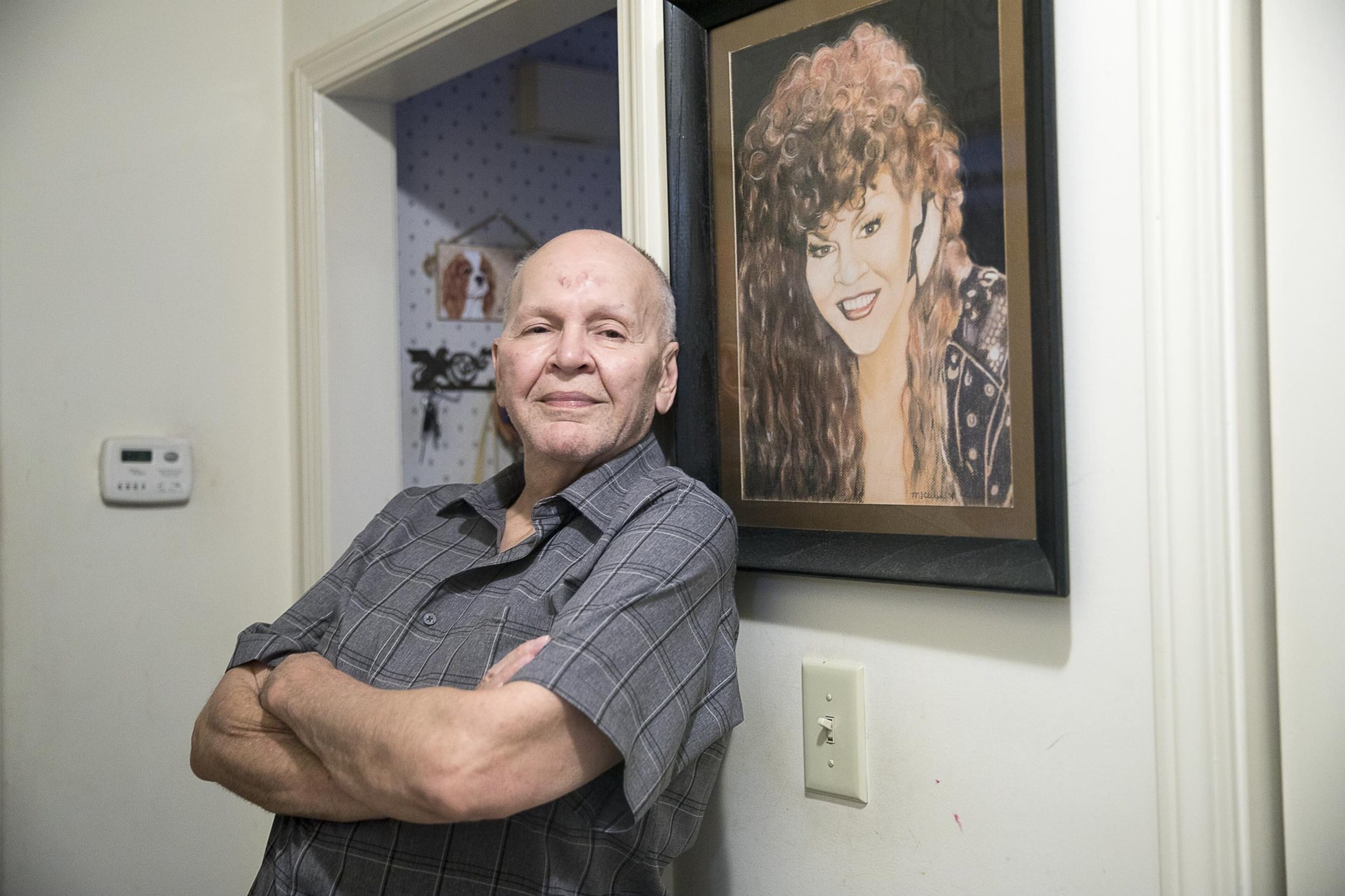 Charles Dillard stands by a gifted painting of himself, performing as Mr. Charlie Brown, that hangs at his residence in Austell. Dillard says that his Aunt Mary lends some of the inspiration for his Mr. Charlie Brown persona.