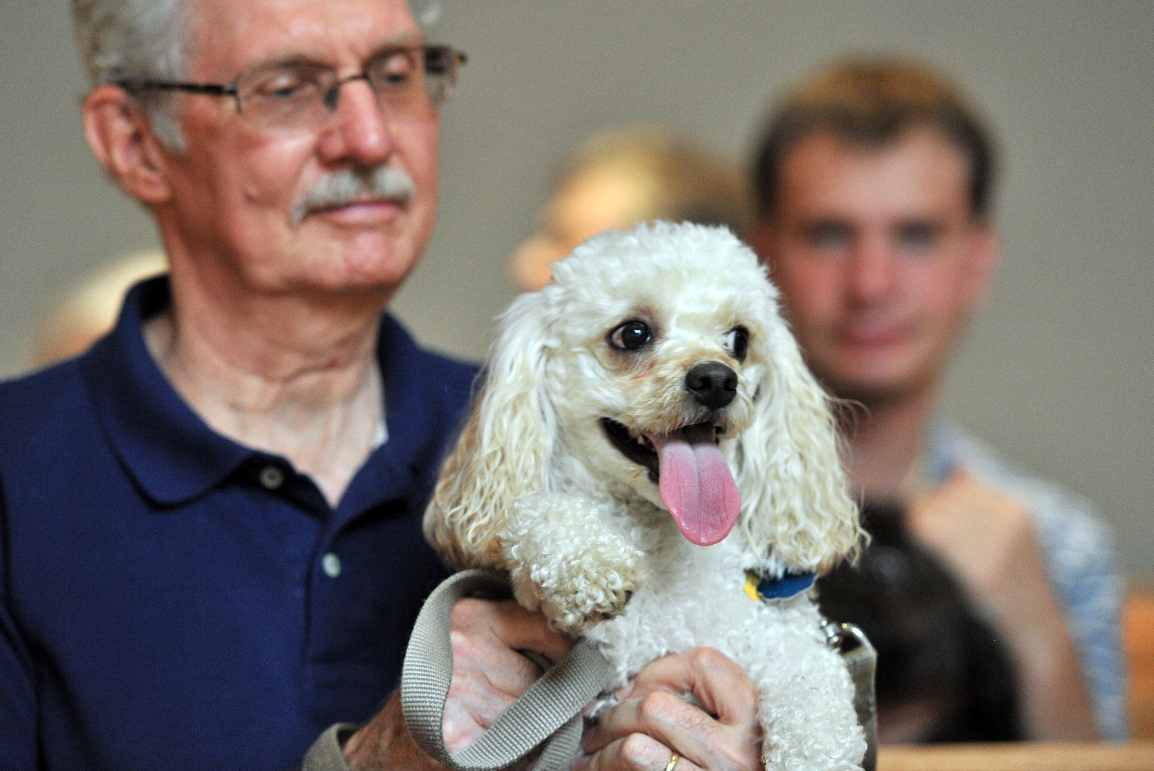 John Willson holds his dog Morgan (Cockapoo) during the Dog Dayz of Summer at Church of the New Covenant in Doraville.