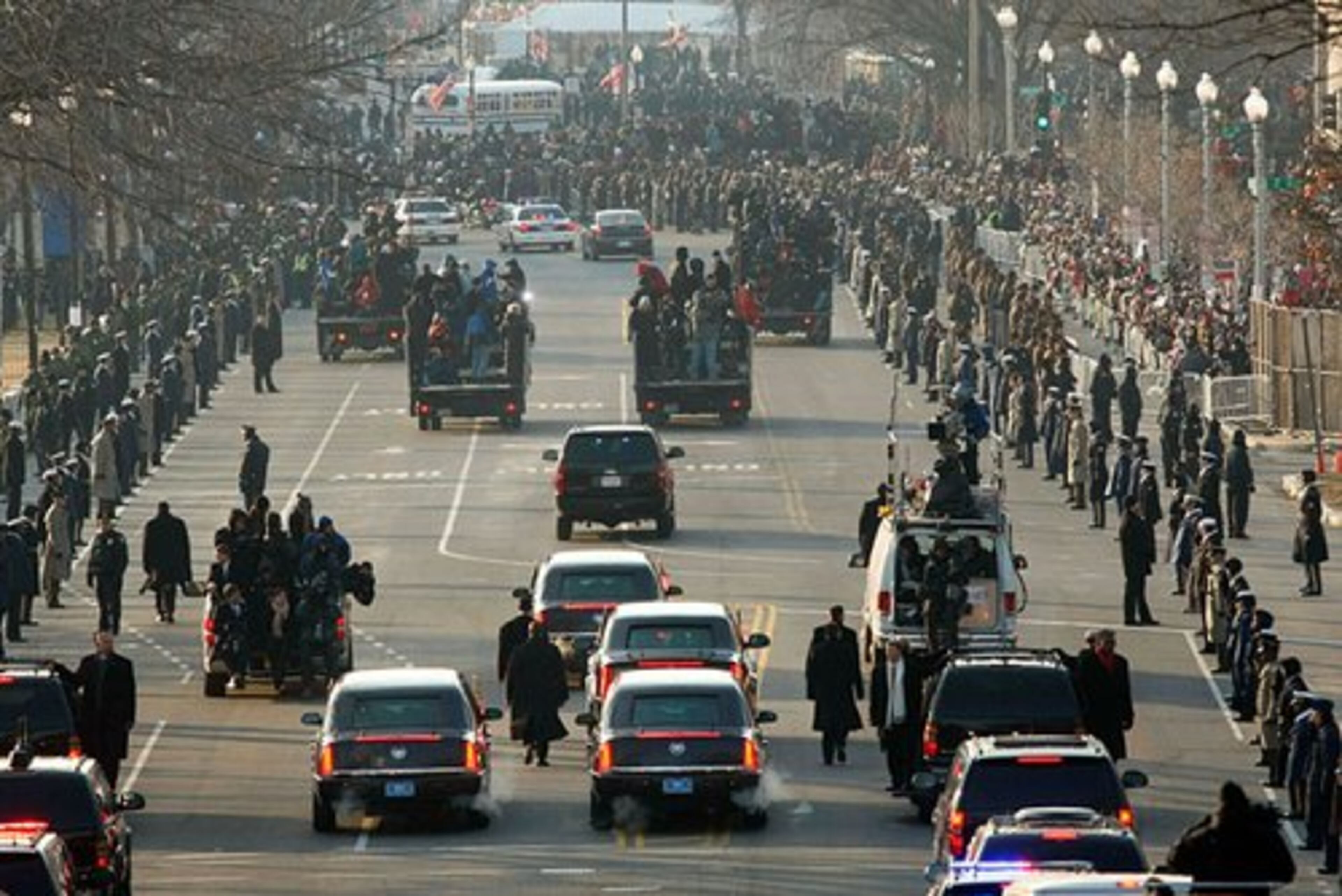 A phalanx of Secret Service agents and camera crews follow alongside Obama's limousine as they go from Capitol Hill to the White House.