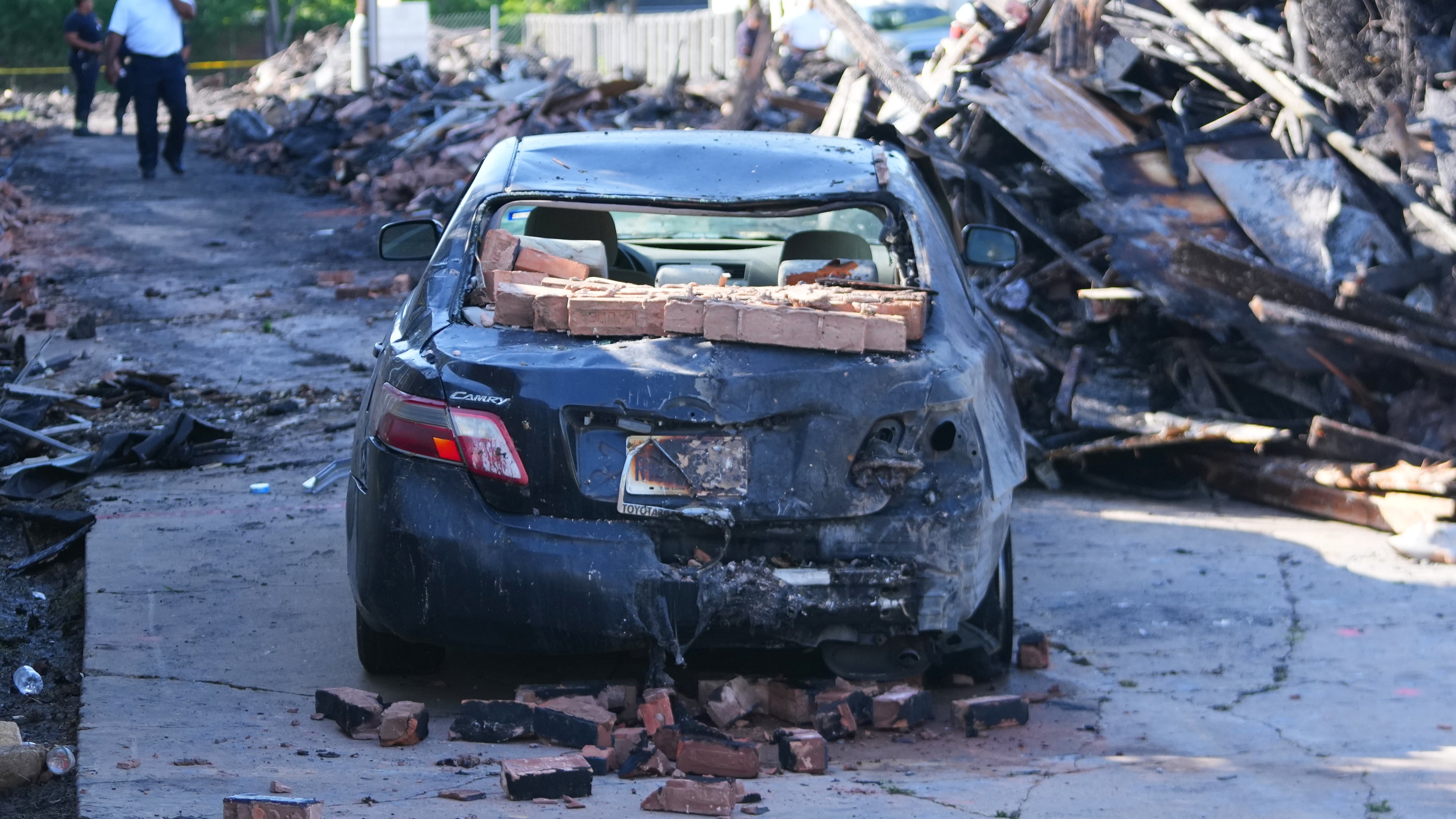 A vehicle is seen damaged following an apartment complex fire, Friday, May 29, 2026, in Dallas. (AP Photo/Julio Cortez)