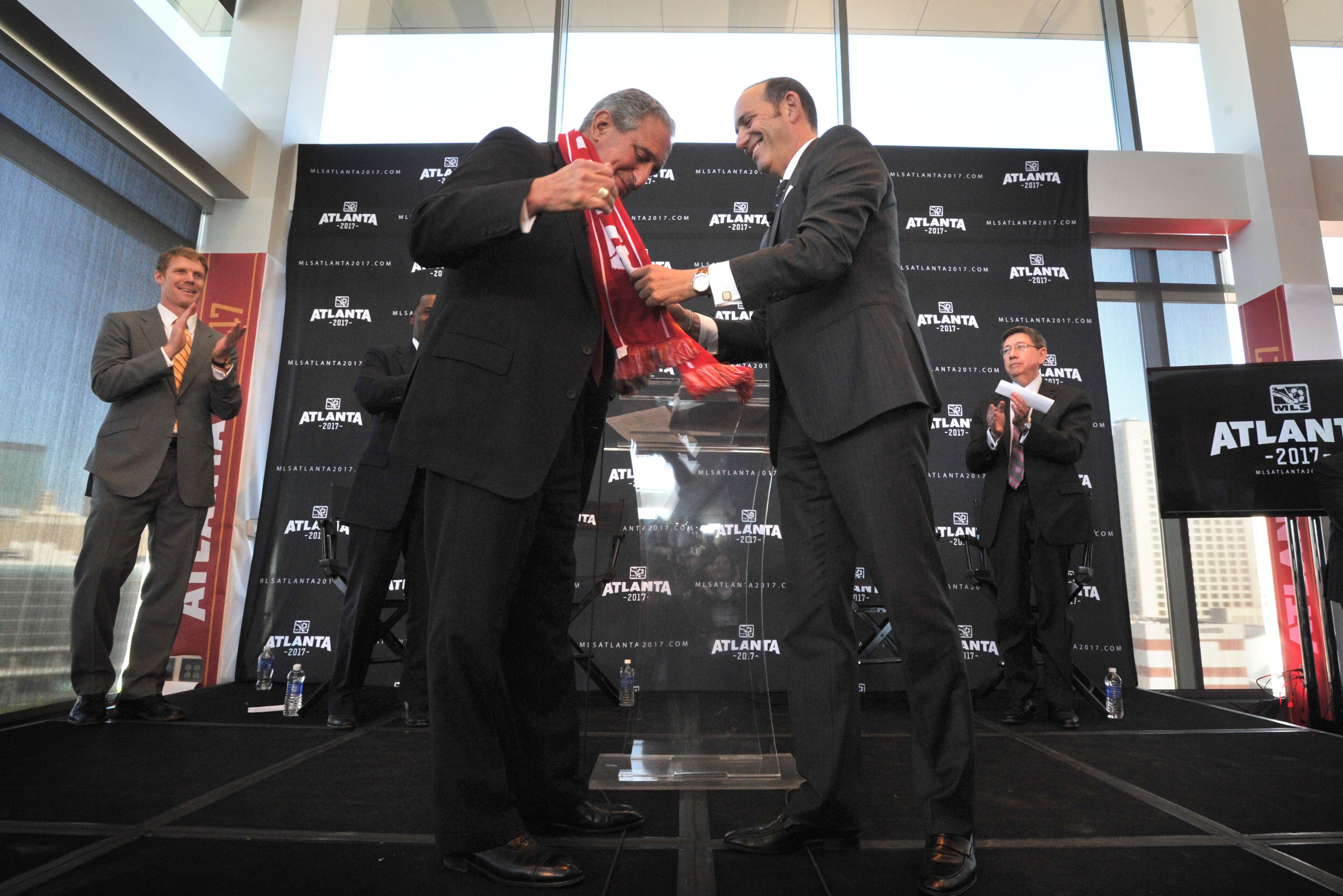 MLS commissioner Don Garber presents a soccer scarf to Falcons owner Arthur Blank during the official announcement event in downtown Atlanta on Wednesday, April 16, 2014. MLS commissioner Don Garber, Falcons owner Arthur Blank, Mayor Kasim Reed, executive director of GWCC Frank Poe and others officially announced that Atlanta will be the 22nd team in MLS on Wednesday downtown amidst a parade-like atmosphere. HYOSUB SHIN / HSHIN@AJC.COM