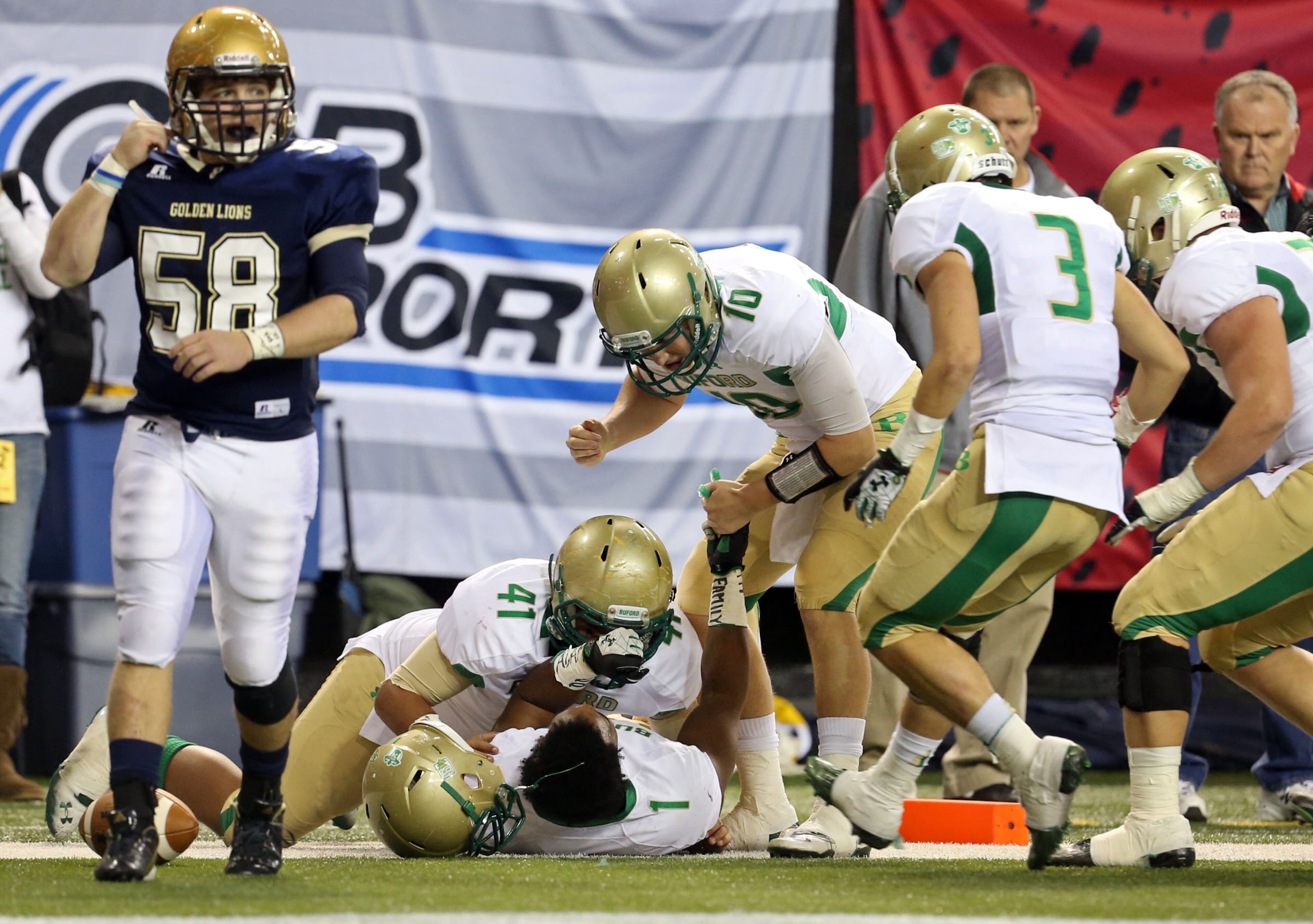 Buford QB Taylor Mitchell (10), running back Jordan Perlotte (41) and teammates celebrate with Wilson after the touchdown.