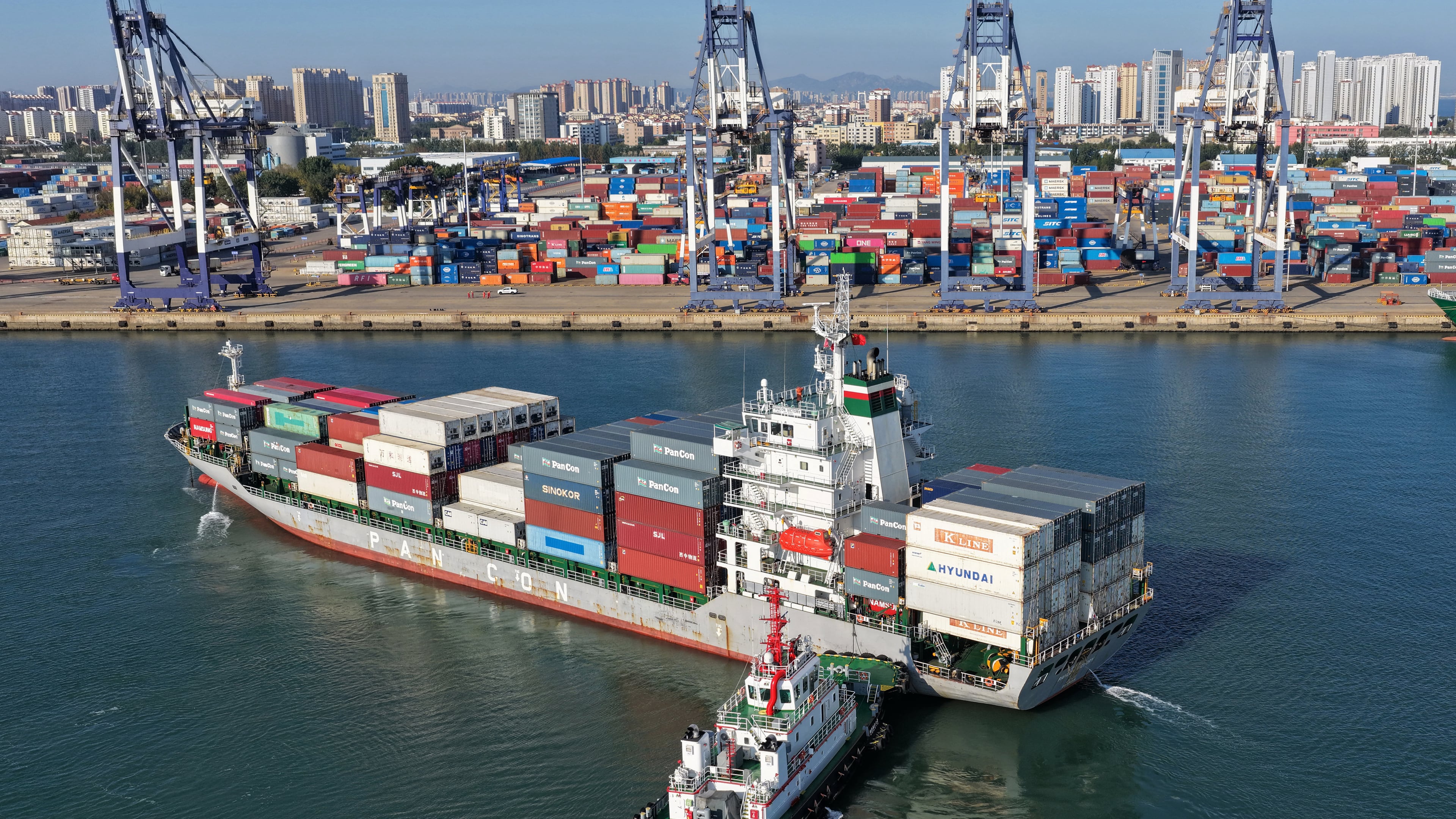 A tugboat pushes a container ship to a port in Yantai, eastern China's Shandong province on Oct. 14, 2026. (Chinatopix via AP)