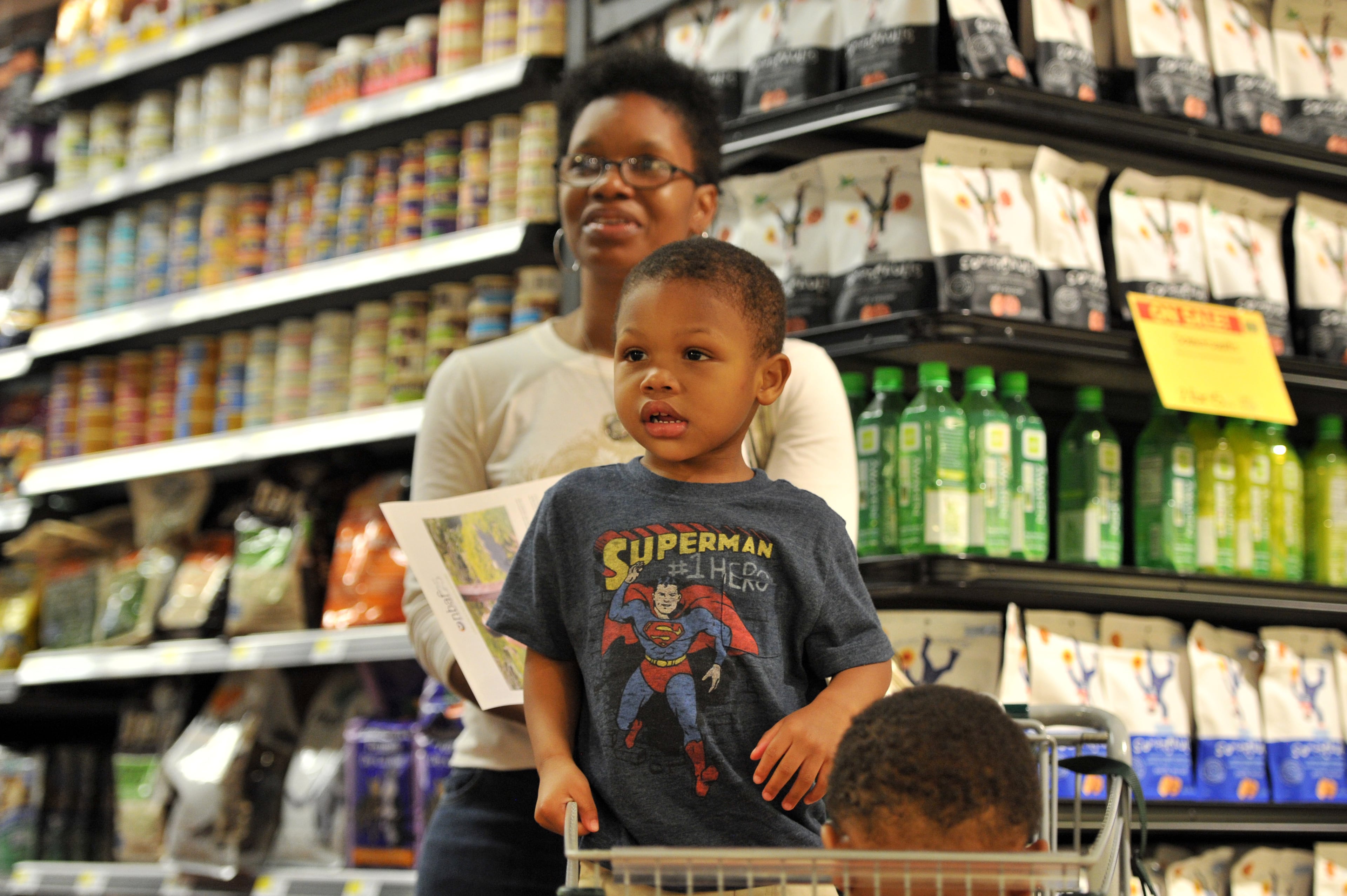 Pamela Redd, of Atlanta, and her 3-year-old son Davis watch as flutist Tara Byrdsong plays classical music as a part of National Black Arts Festival "Unexpected Encounters" series at Whole Foods Market on Ponce de Leon Avenue in Atlanta. HYOSUB SHIN / HSHIN@AJC.COM