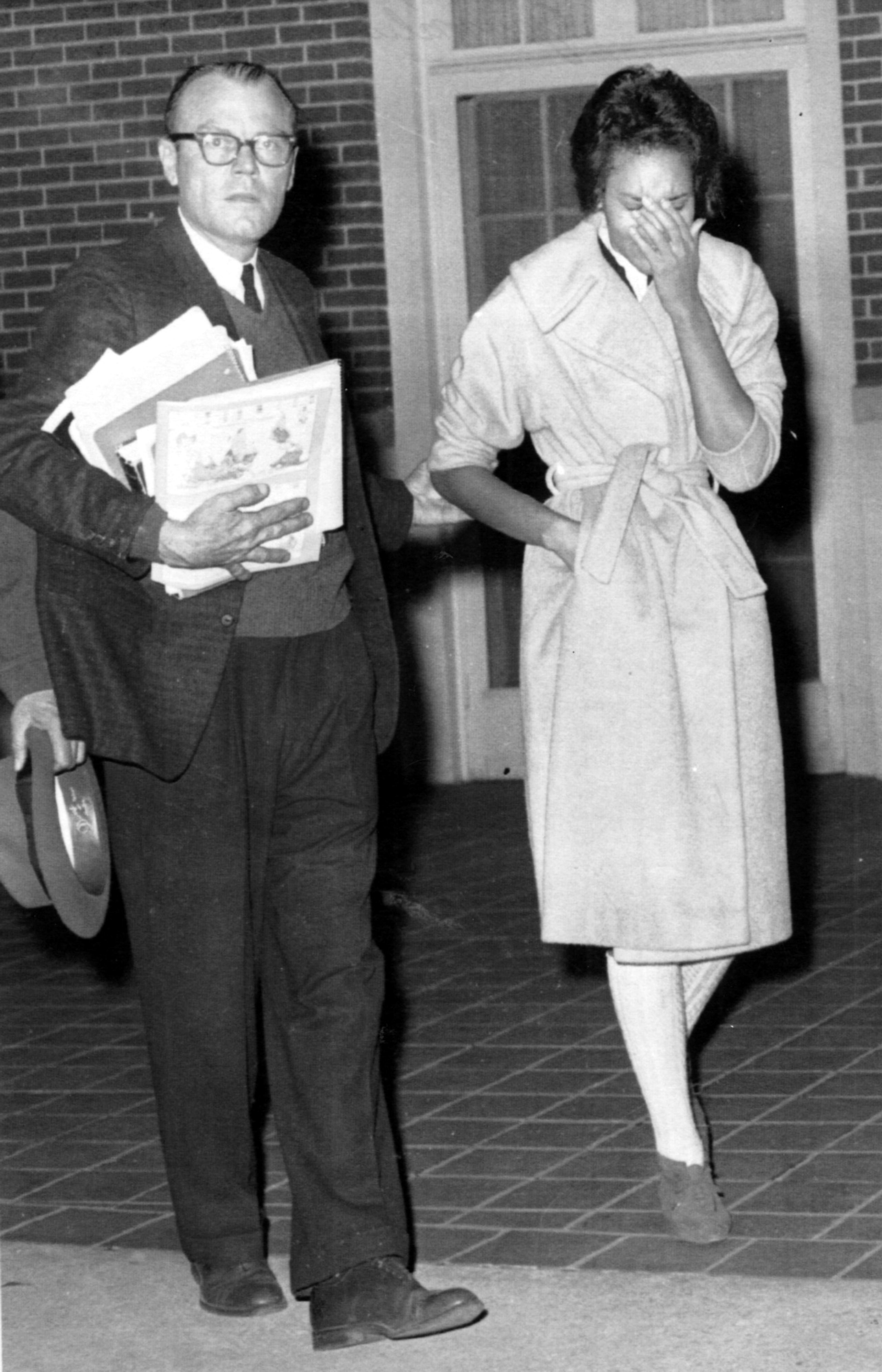 Charlayne Hunter is escorted from her dormitory at the University of Georgia by an unidentified official in this January 1961 photo following rioting outside her window. She was wisked away by state troopers and was later re-admitted to the school. AP