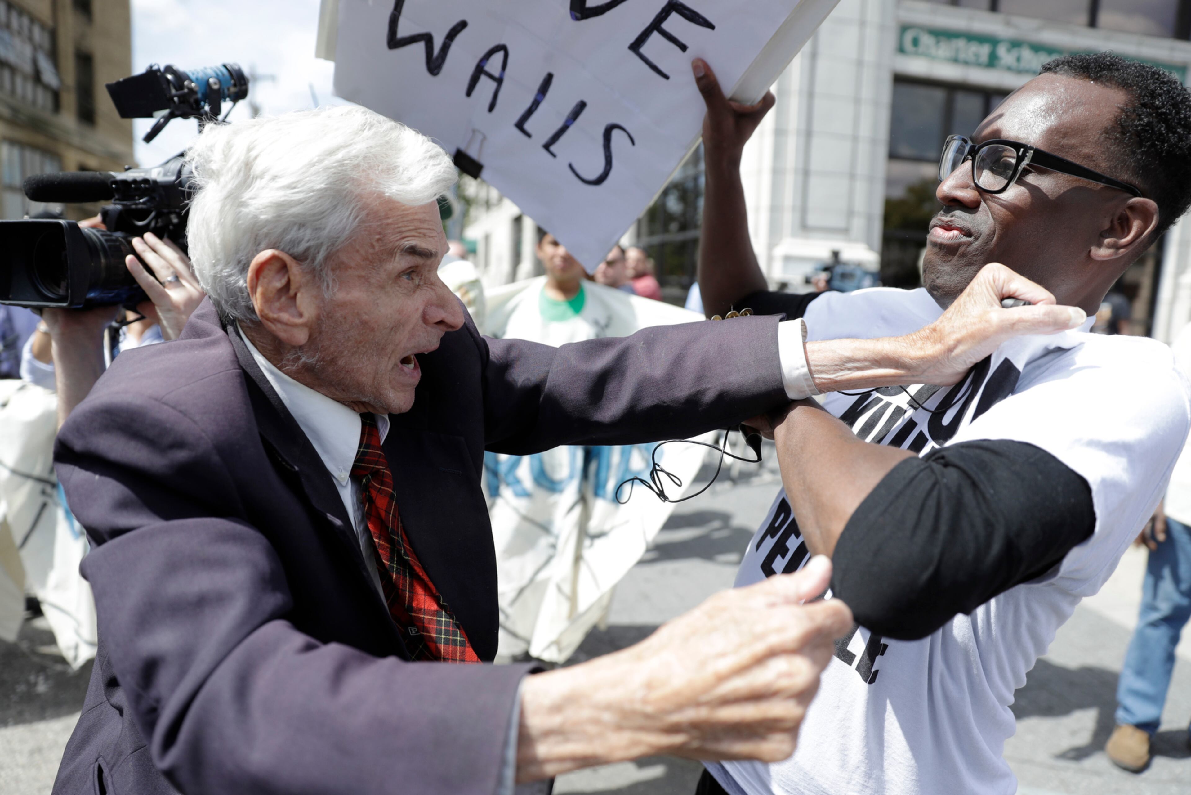 Jerry Lambert, left, a supporter of Republican presidential candidate Donald Trump, and Asa Khalif with Black Lives Matter scuffle, after Khalif took Lambert's sign, outside the location where Trump is to meet with African American business and civic leaders in Philadelphia, Friday, Sept. 2, 2016. (AP Photo/Matt Rourke)
