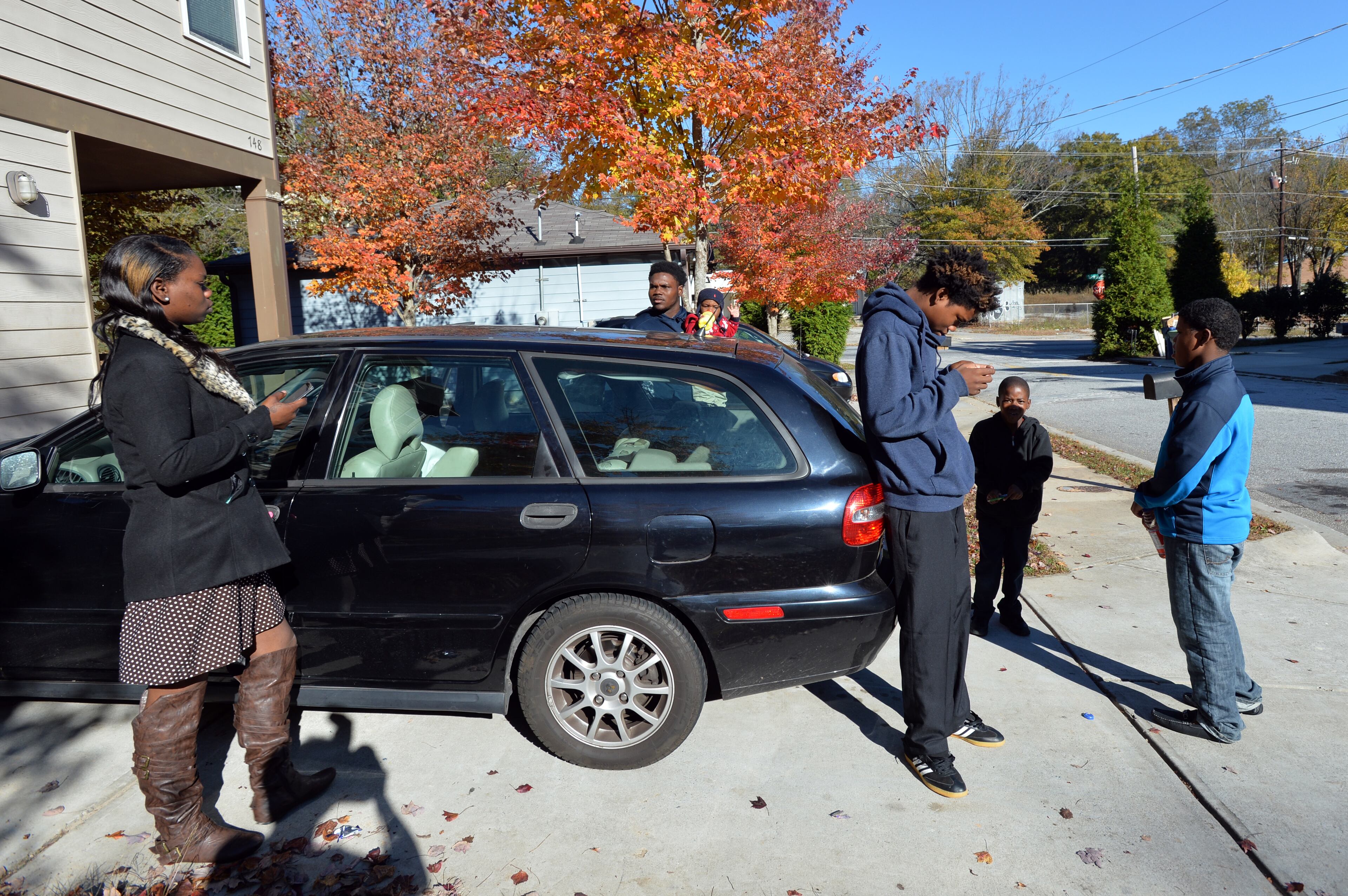 Ashley Roberson (left), 23, tries to figure out how to get everyone in the car with her brothers (from left) Darius, 18, holding her son Demetrius Broadnax Jr., 1, Dayzhon, 15, Damyuss, 8, and Dazmine, 12, to their church after she heard her pastor was not able to pick them up outside their home on Sunday morning. HYOSUB SHIN / HSHIN@AJC.COM