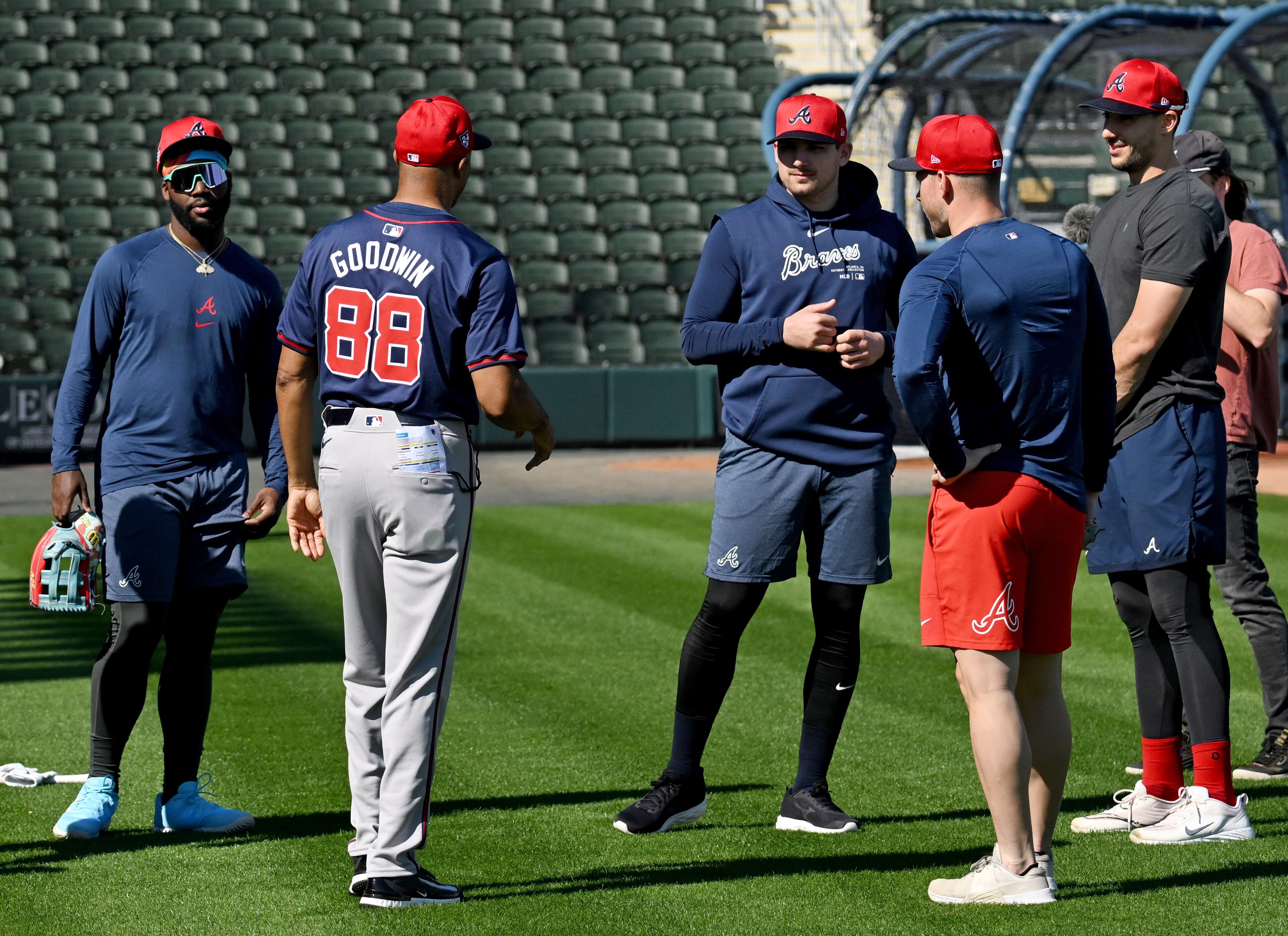 Atlanta Braves first base coach Tom Goodwin (88) speaks to Atlanta Braves (from left) center fielder Michael Harris II, third baseman Austin Riley and first baseman Matt Olson during spring training baseball workouts at CoolToday Park, Thursday, February, 15, 2024, in North Port, Florida. (Hyosub Shin / Hyosub.Shin@ajc.com)