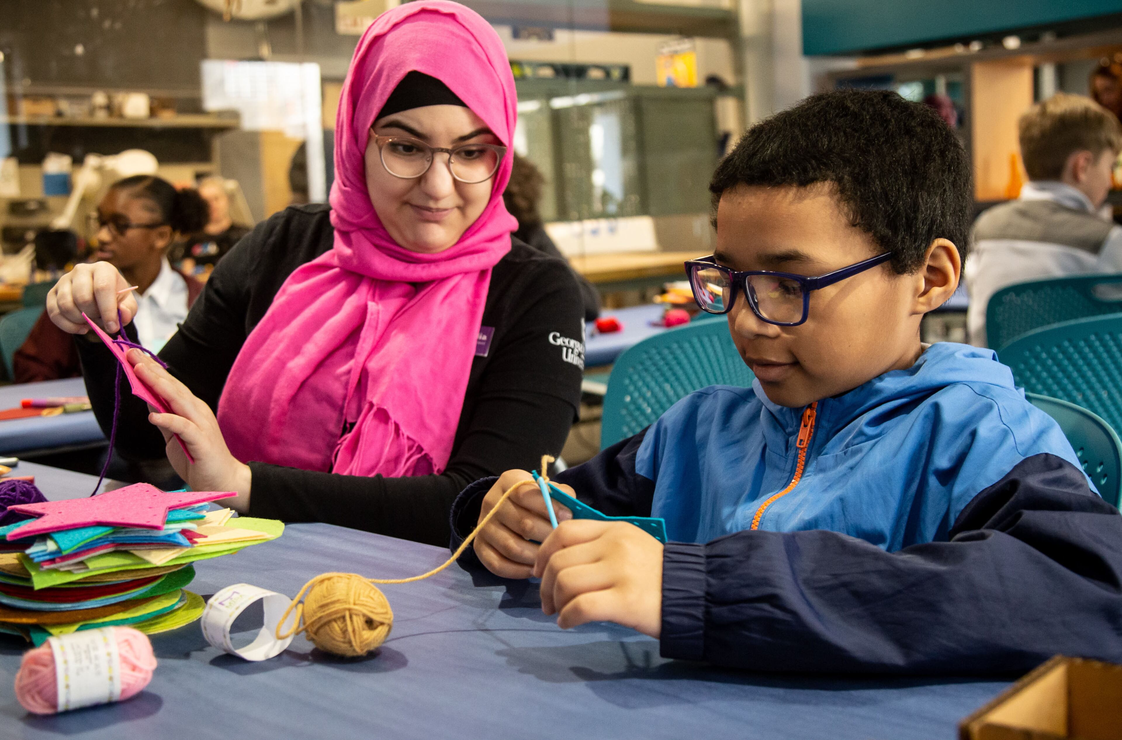 Nadia Qutob (L) helps Ethan Sims with his sewing project during the Genius Camp in the ExLab at Georgia State University on Saturday, March 7, 2020. STEVE SCHAEFER / SPECIAL TO THE AJC