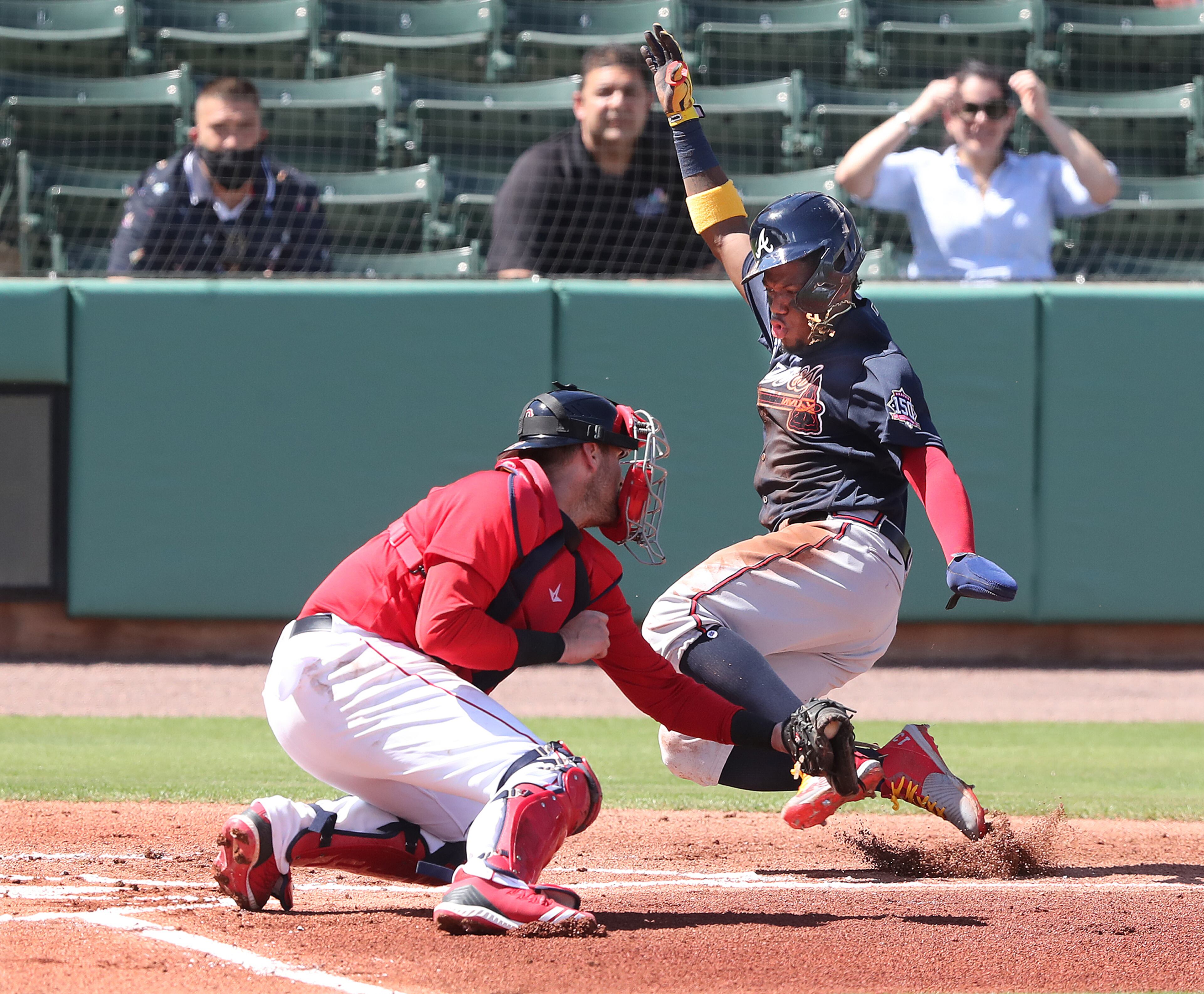 Atlanta Braves outfielder Ronald Acuna just beats the tag by Boston Red Sox catcher Jett Bandy to score on a RBI single by Jake Lamb and give Atlanta a 1-0 lead in the first inning Monday, March 1, 2021, at JetBlue Park in Fort Myers, Fla. (Curtis Compton / Curtis.Compton@ajc.com)