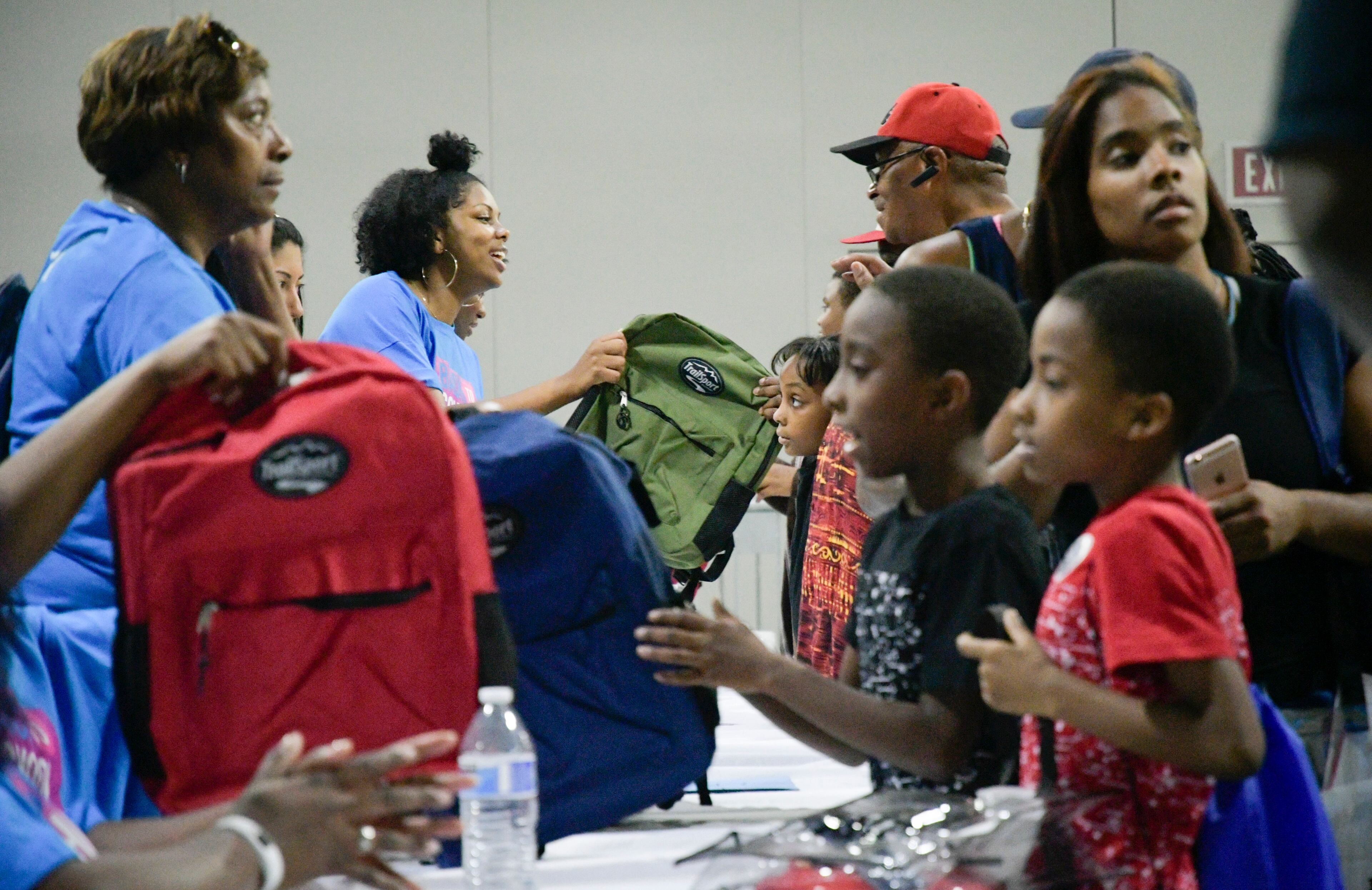 Ruqayya Calmes, 23, second from left, helps volunteers helping pass out backpacks as APS students kick of the school year right during the District's annual Back to School Bash, Saturday, July 28 at the Georgia World Congress Center as a free event, held exclusively for APS students and their families, featuring more fun activities for children, immunizations, and free health screenings.