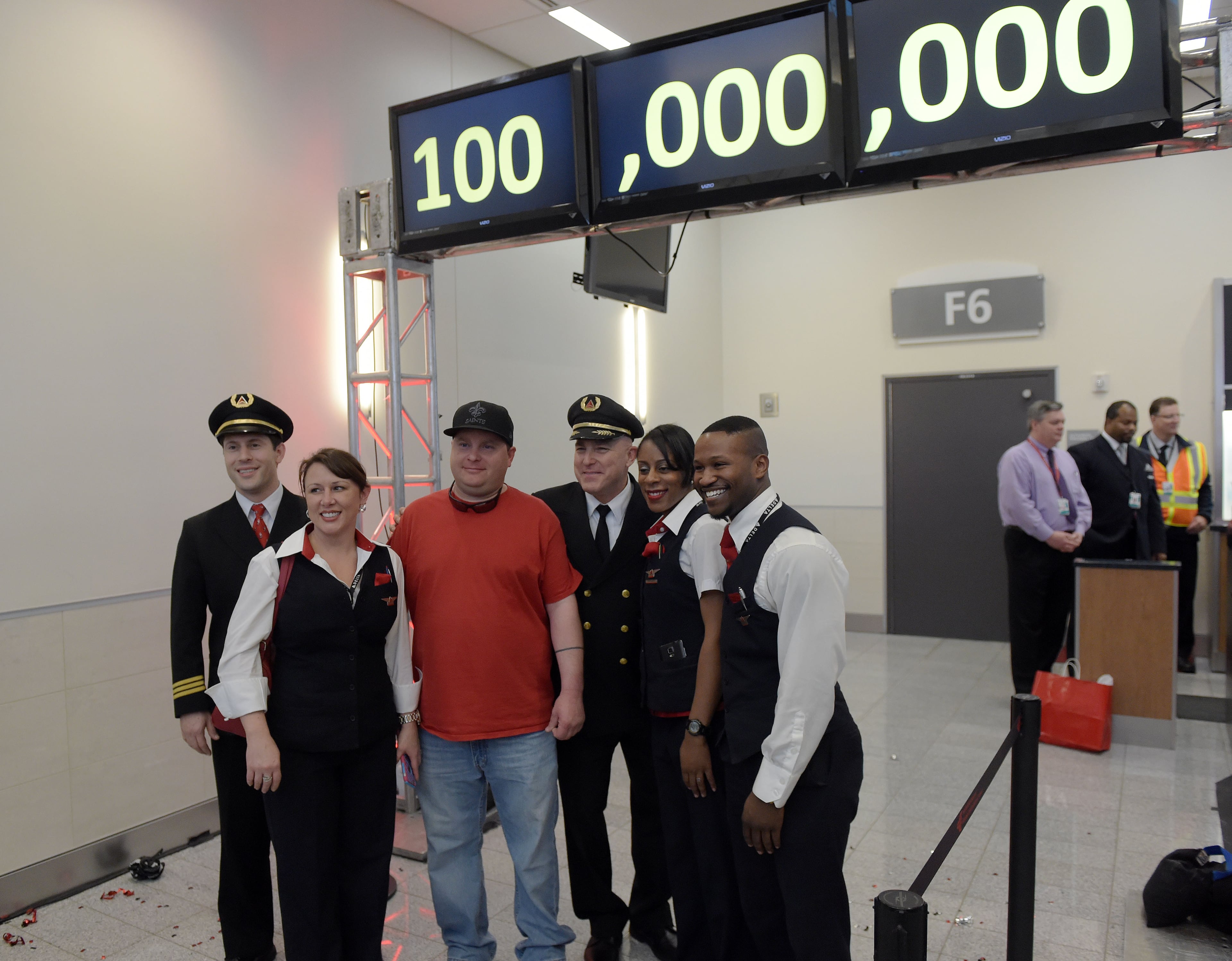 Passenger Larry Kendrick poses for photos with the Delta flight crew. Hartsfield-Jackson International Airport awarded its 100 millionth passenger for 2015 with prizes including a new car, two free airline tickets and a small crowd of officials and television cameras early Sunday December 27, 2015. The Atlanta airport, "the world's busiest" is the first airport in the world to handle 100 million passengers in a year. "It's our commitment that we maintain our position as the world's most traveled airport," said Atlanta Mayor Kasim Reed during remarks at the airport before the flight arrived Sunday morning. The winner, a man from Biloxi named Larry Kendrick who arrived at the airport in blue jeans, an orange t-shirt and a baseball cap, was surprised to learn upon landing that he had been selected as the 100 millionth passenger. KENT D. JOHNSON/ kdjohnson@ajc.com