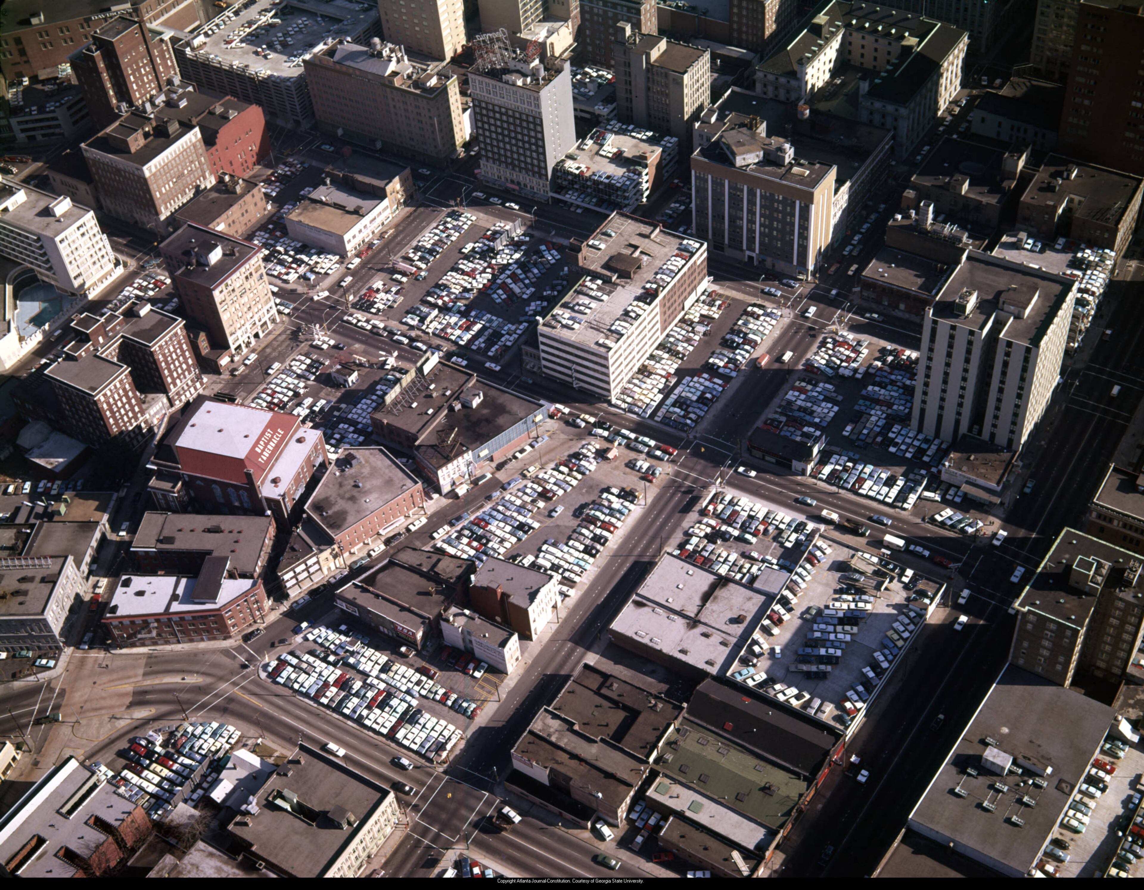 Aerial view of downtown, looking northeast, showing large areas covered in parking lots, Atlanta, Georgia, December 21, 1965. Marietta Street is the large street running near the bottom right corner. The first intersection we see is at Spring Street. Note the Baptist Tabernacle just left of center, today known as The Tabernacle. Photo: Floyd Edwin Jillson