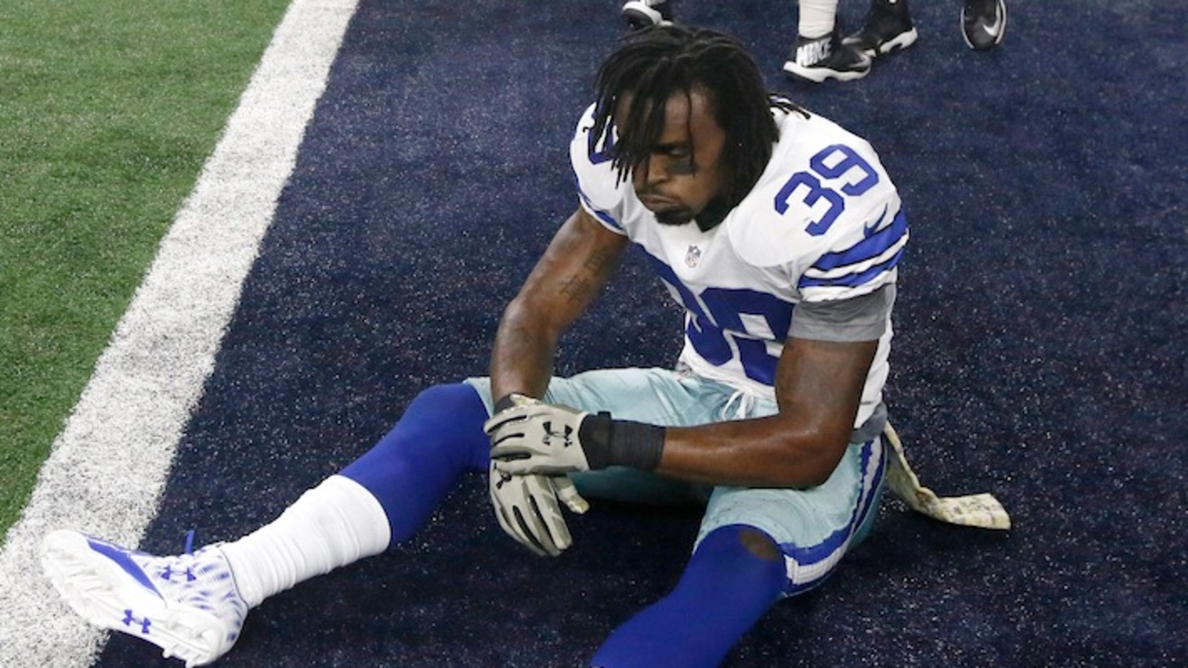 Dallas Cowboys' Brandon Carr (39) sits on the field as Philadelphia Eagles' Josh Andrews (68) celebrates with teammates after the Eagles 33-27 in in overtime of an NFL football game Sunday, Nov. 8, 2015, in Arlington, Texas. (AP Photo/Michael Ainsworth)