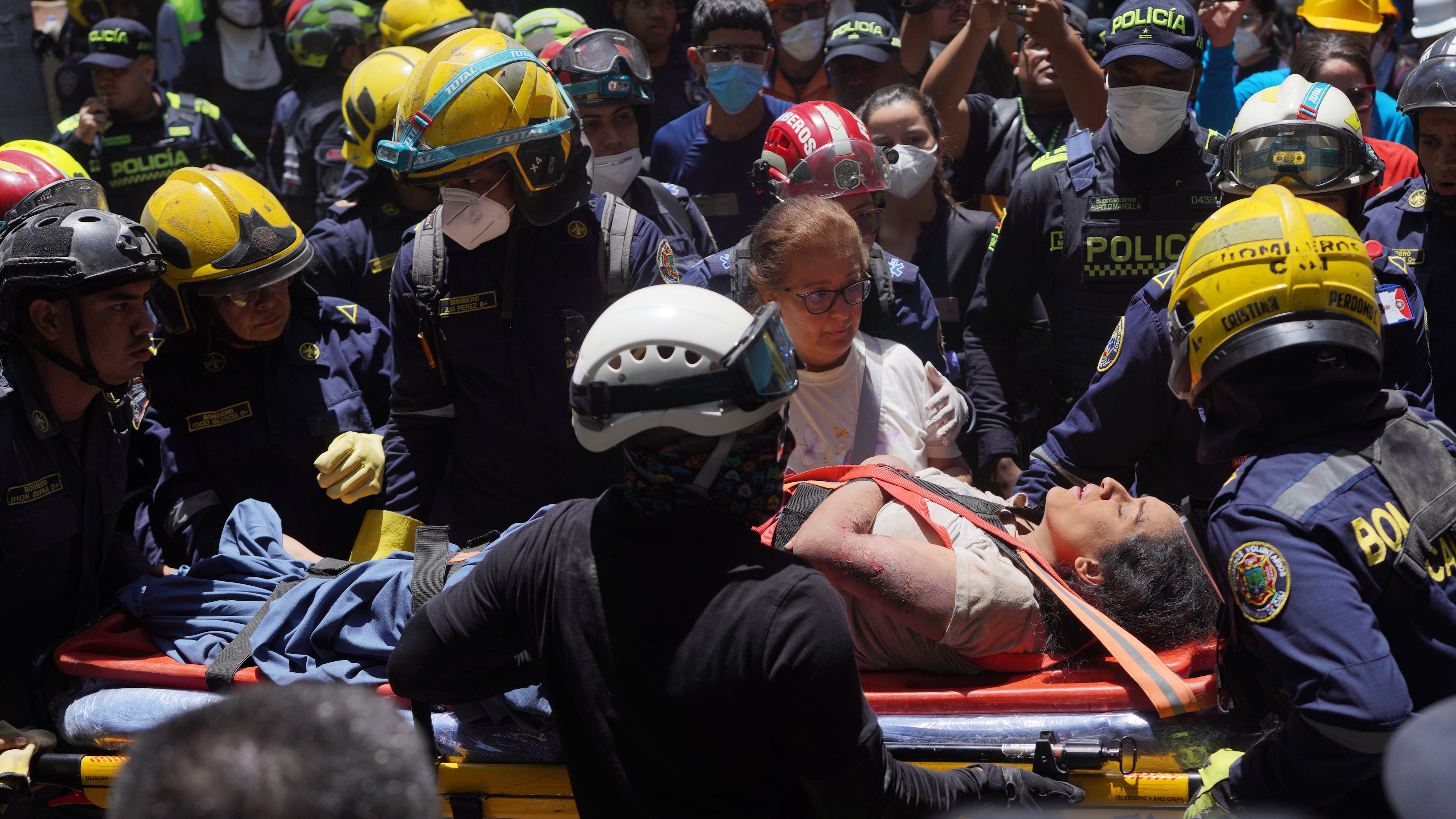 Rescue workers carry Diana Troncoso after pulling her from the rubble the day after an earthquake struck Cali, Colombia, Tuesday, Aug. 11, 2026. (AP Photo/Ivan Valencia) CORRECTION: Changes city to Cali, not Pereira.