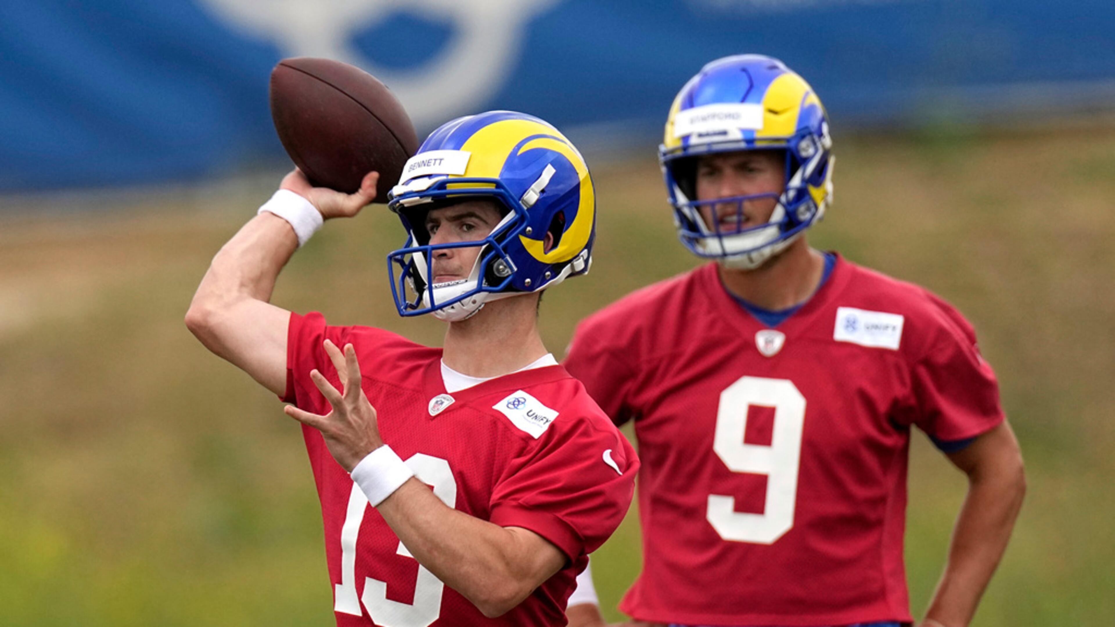 Los Angeles Rams backup quarterback Stetson Bennett, left, passes as quarterback Matthew Stafford watches during the NFL football team's organized activities Wednesday, May 31, 2023, in Thousand Oaks, Calif. (AP Photo/Mark J. Terrill)