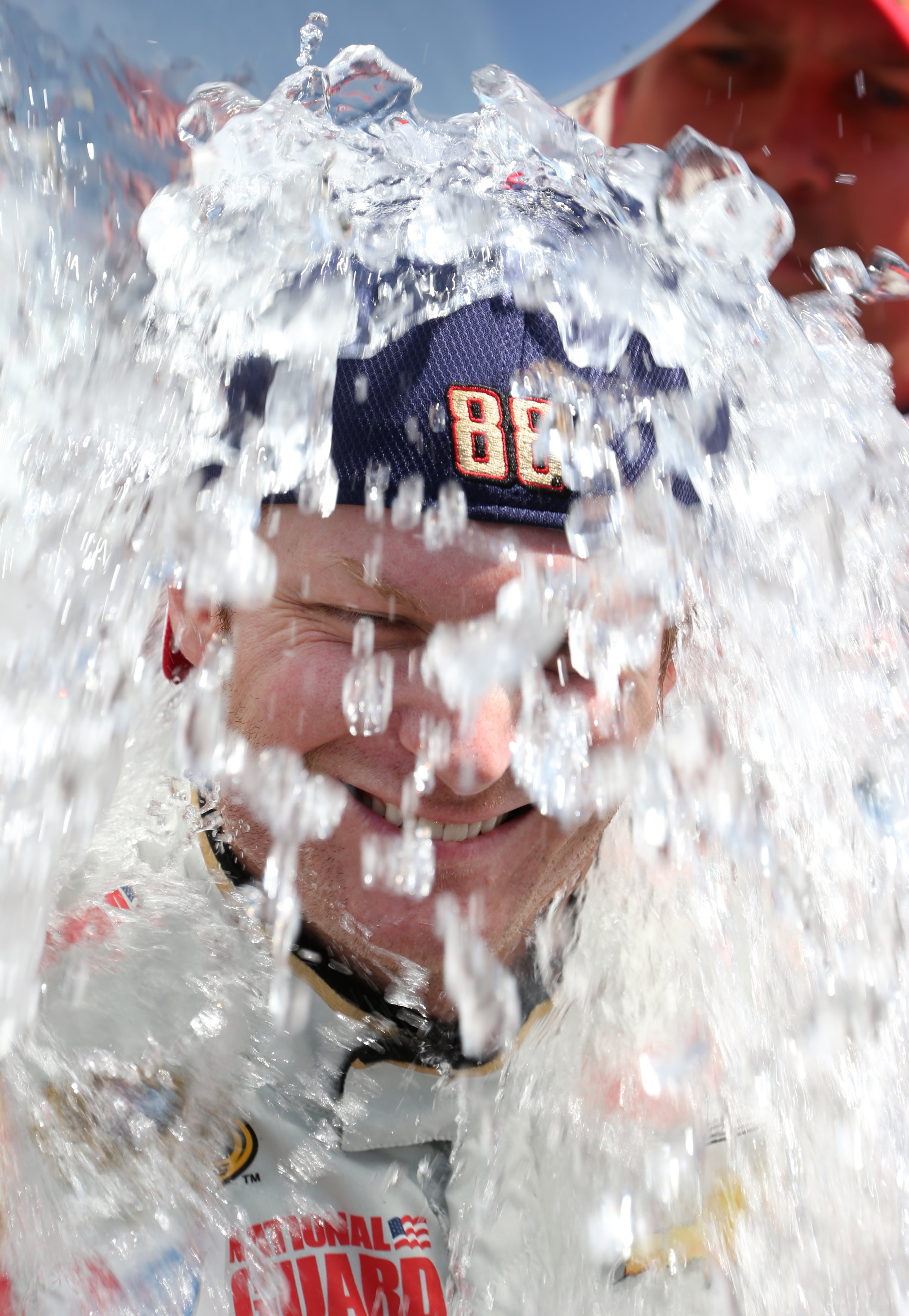Dale Earnhardt Jr. smiles while taking the ice bucket challenge after practice for the NASCAR Sprint Cup series auto race at Michigan International Speedway in Brooklyn, Mich., Friday, Aug. 15, 2014. The challenge, in which participants get a bucket of water and ice cubes dumped on their heads, raises money to fight ALS, or Lou Gehrig's disease. (AP Photo/Bob Brodbeck)