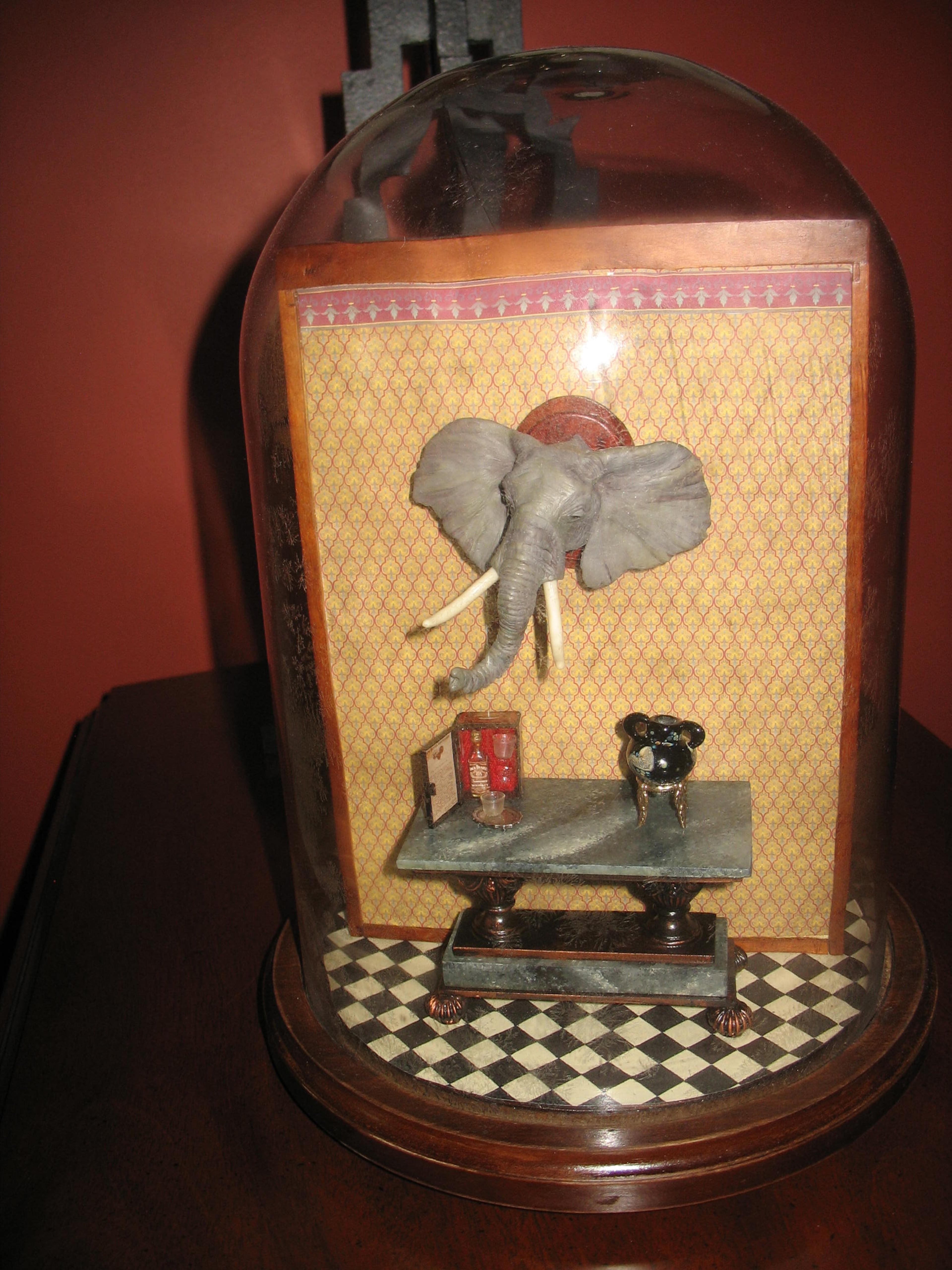 Clever room boxes are part of the decor of Atlanta Miniature Society member Clarice Elder's Dunwoody home. This is a two-sided room under a glass dome, which rotates. One side shows a gentleman dressing, while the other side represents the place a man goes to relax -- right down to the miniature bottle of Jack Daniel's and the hunting trophy on the wall.