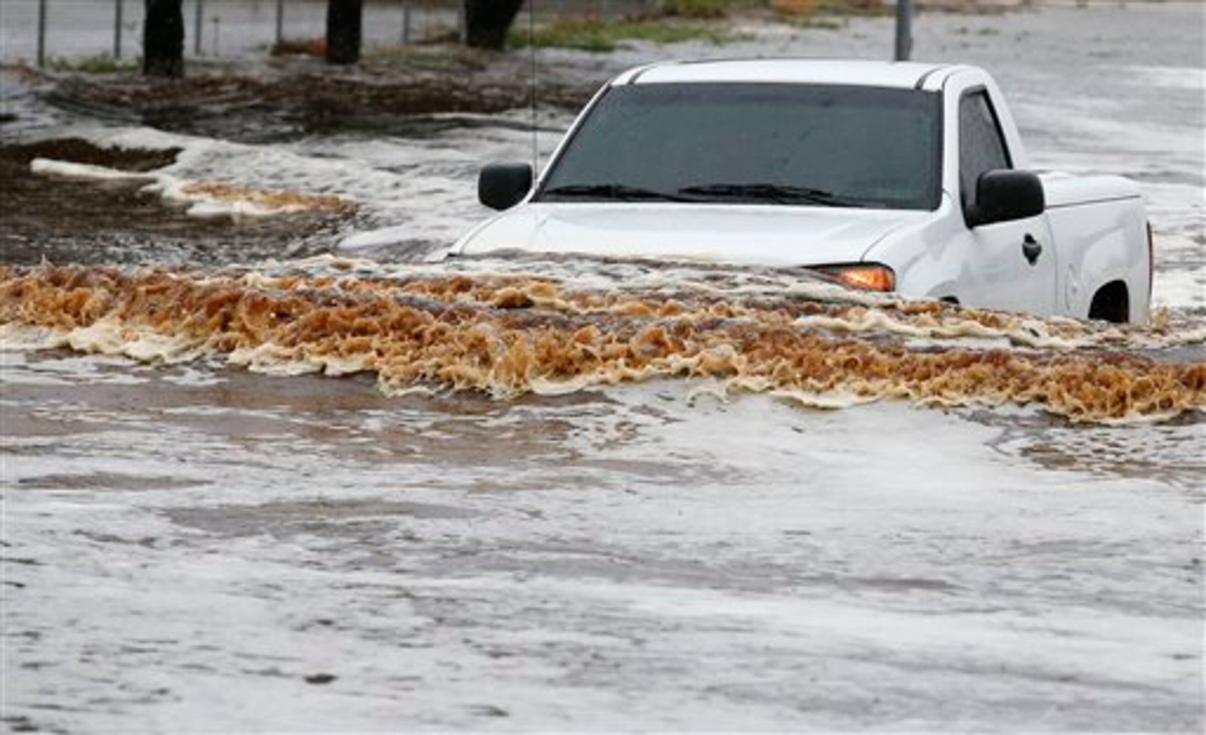 A pick-up truck driver tries to navigate a severely flooded street as heavy rains pour down Monday, Sept. 8, 2014, in Phoenix. Storms that flooded several Phoenix-area freeways and numerous local streets during the Monday morning commute set an all-time record for rainfall in Phoenix in a single day. (AP Photo/Ross D. Franklin)