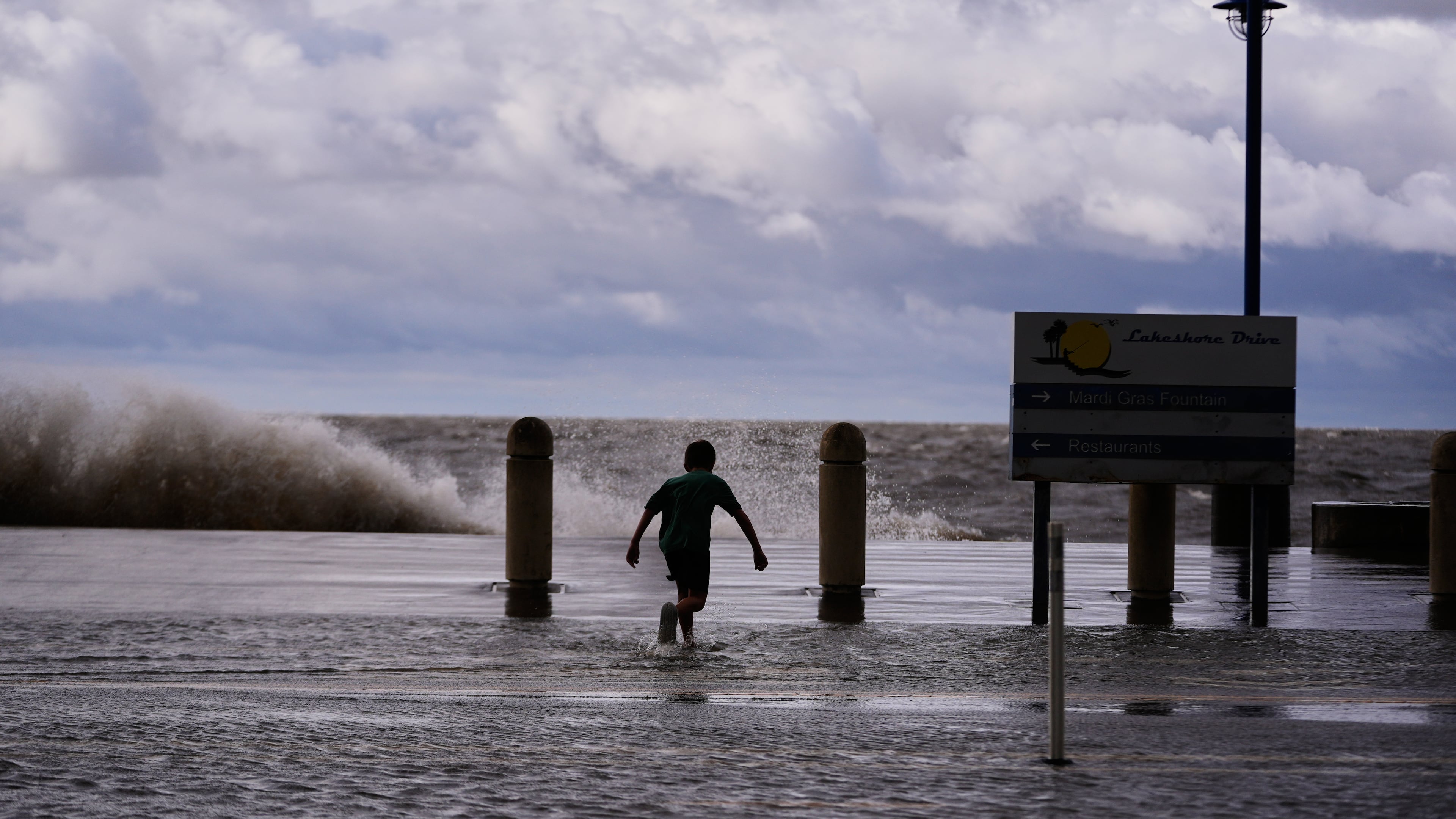 Josiah Carpenter, 8, frolics in the floodwaters on Lakeshore Drive along Lake Pontchartrain as Tropical Storm Bertha approaches the Louisiana Coast Wednesday, July 22, 2026, in New Orleans. (AP Photo/Gerald Herbert)