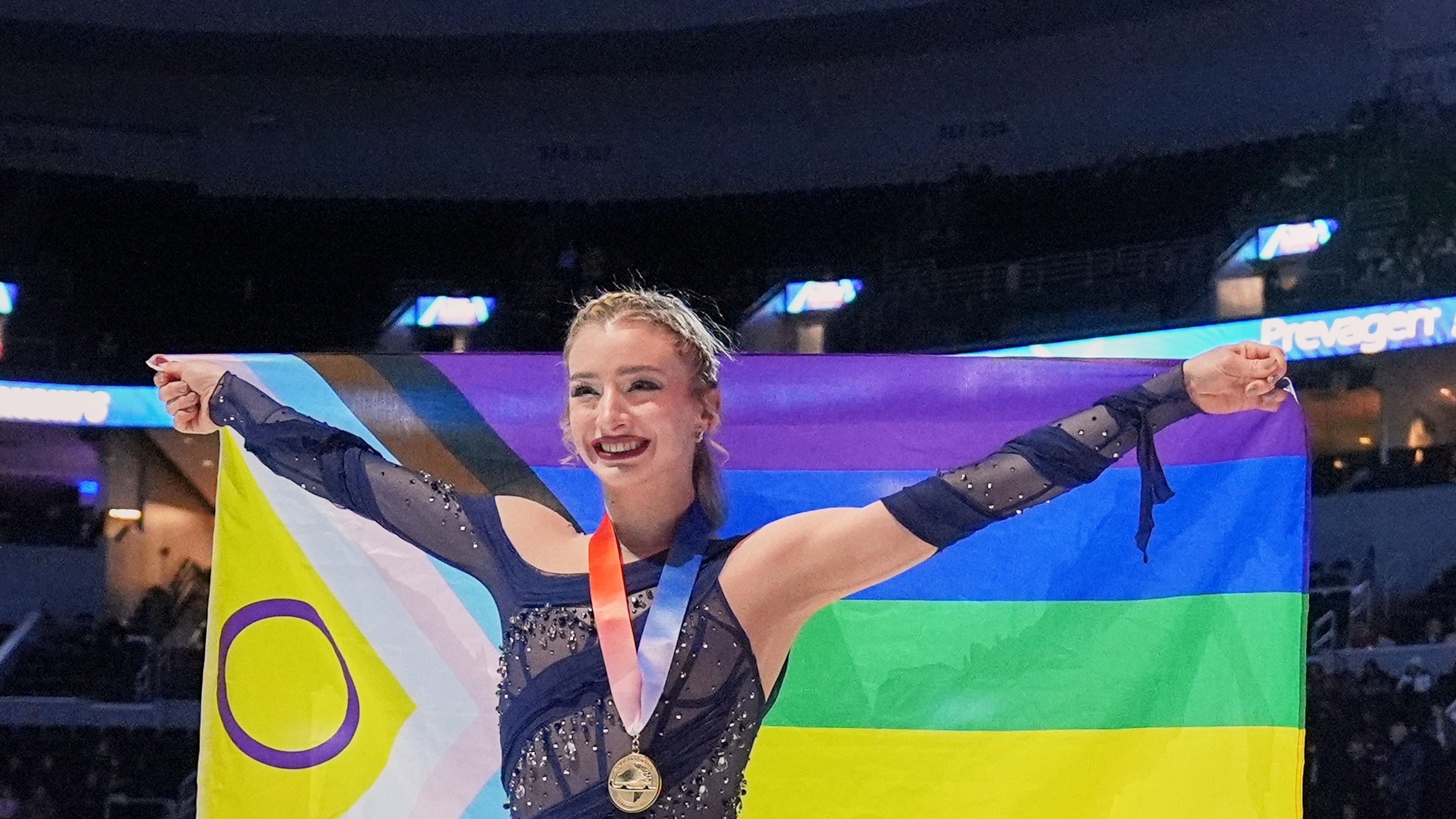 Gold medalist Amber Glenn poses with a flag after the women's free skating competition at the U.S. Figure Skating Championships, Friday, Jan. 9, 2026, in St. Louis. (AP Photo/Stephanie Scarbrough)