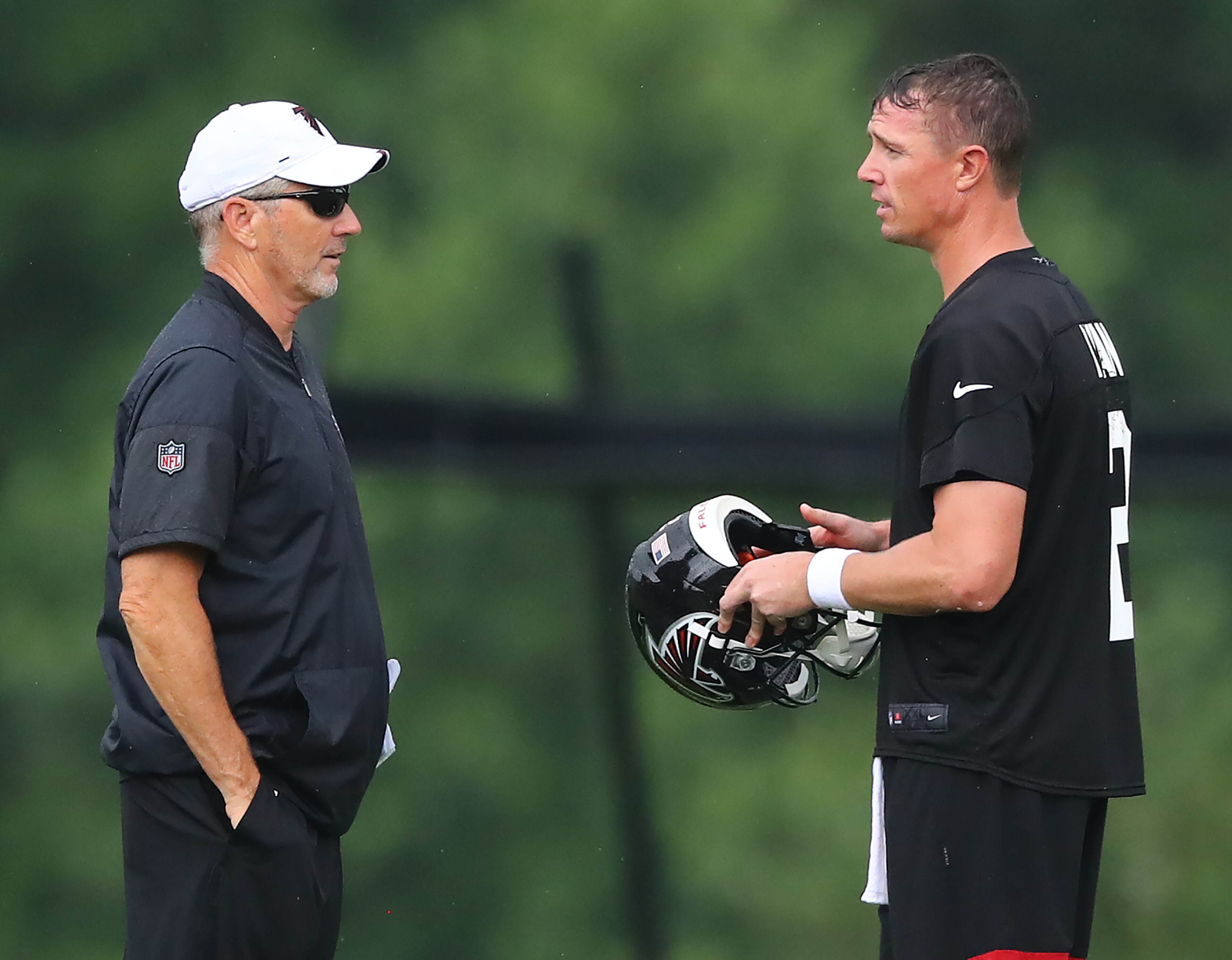 Falcons offensive coordinator Dirk Koetter confers with Matt Ryan during the second practice at training camp on Tuesday in Flowery Branch. Curtis Compton/ccompton@ajc.com