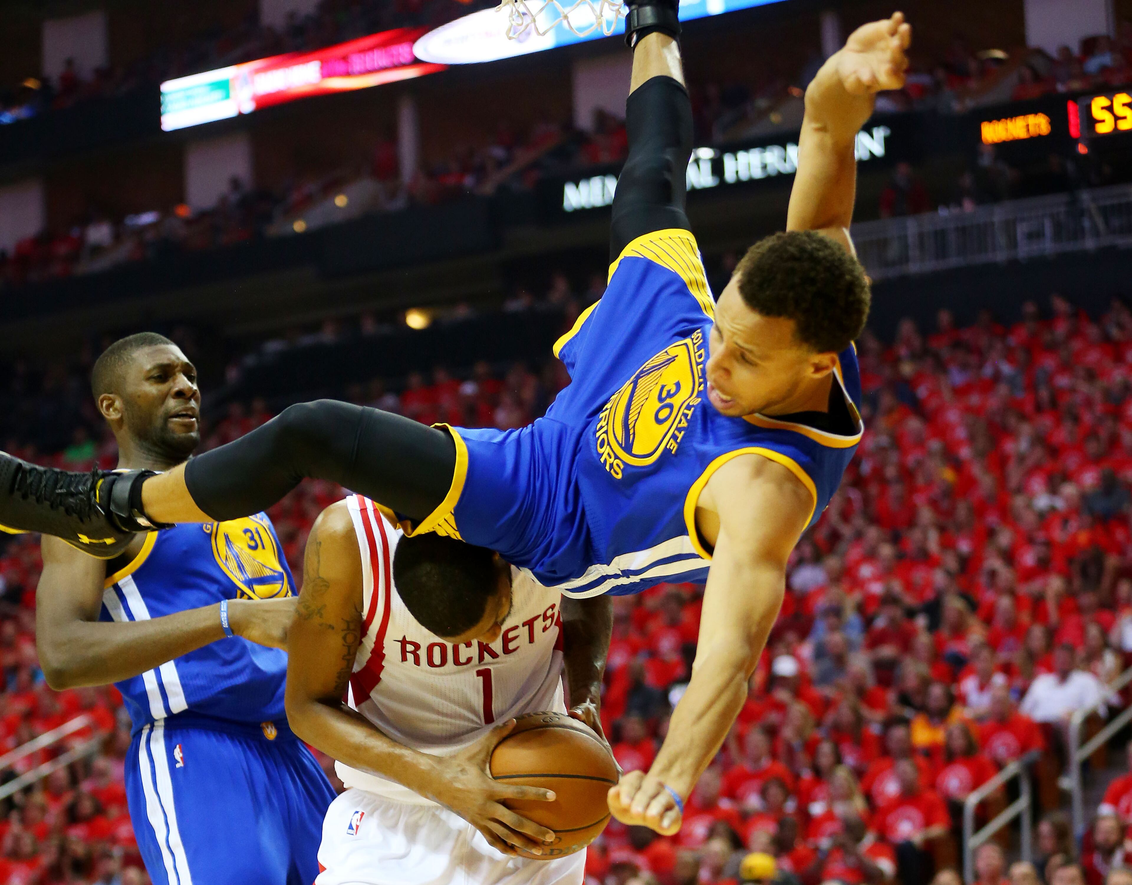 HOUSTON, TX - MAY 25: Stephen Curry #30 of the Golden State Warriors falls over Trevor Ariza #1 of the Houston Rockets on his way to an injury in the second quarter during Game Four of the Western Conference Finals of the 2015 NBA Playoffs at Toyota Center on May 25, 2015 in Houston, Texas. NOTE TO USER: User expressly acknowledges and agrees that, by downloading and or using this photograph, user is consenting to the terms and conditions of Getty Images License Agreement. (Photo by Ronald Martinez/Getty Images)