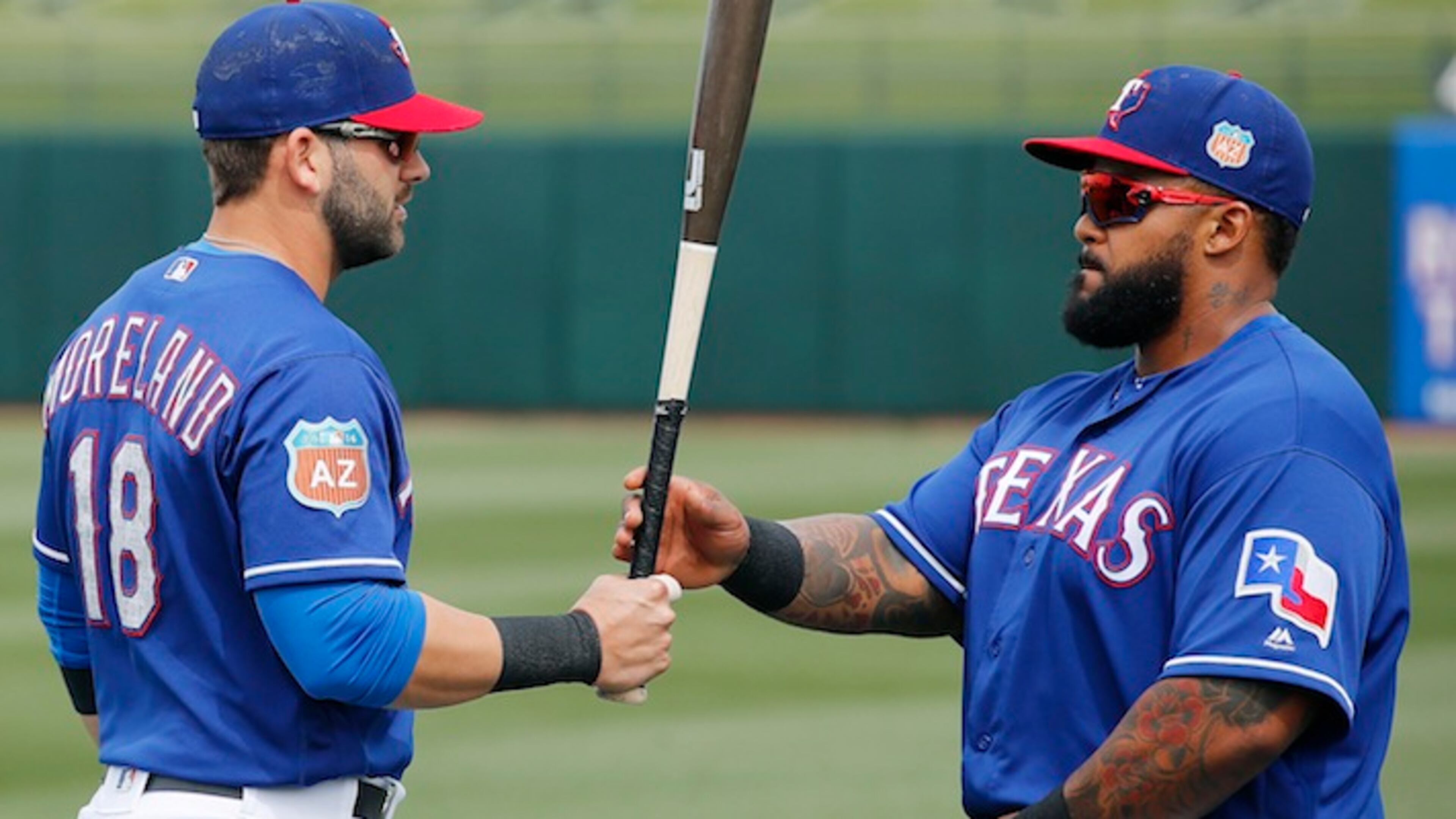Texas Rangers' Mitch Moreland (18) talks with Prince Fielder, right, prior to a spring training baseball game against the San Francisco Giants Monday, March 7, 2016, in Surprise, Ariz. (AP Photo/Ross D. Franklin)