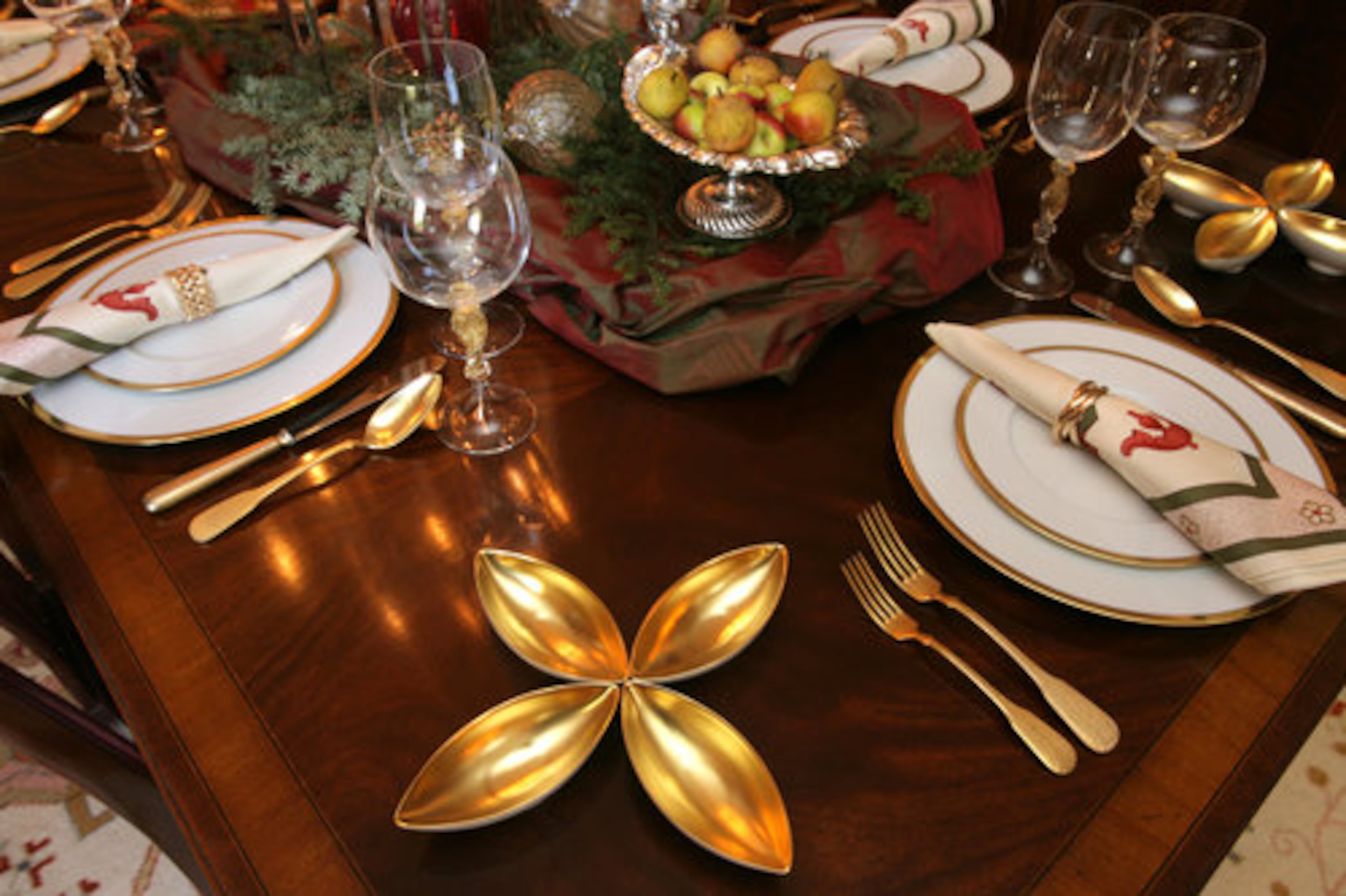 Halpern suggests using fabric in the center of the table to protect the wood. He simply purchased a couple yards of taffeta from Lewis and Sheron Textiles for this display. Antique silver filled with apples or nuts adds a traditional note.