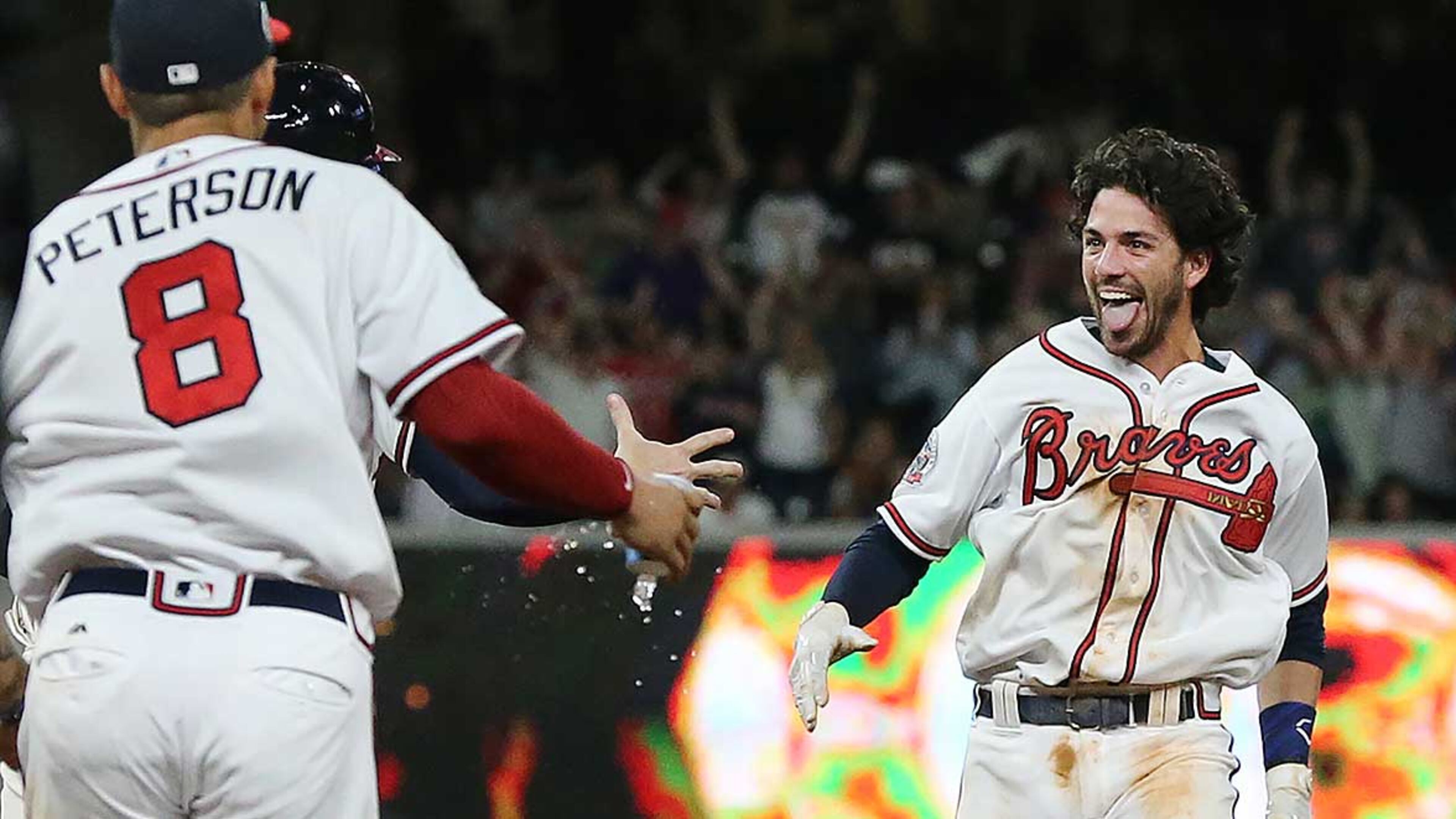 Jace Peterson and the rest of the Atlanta Braves rush the field to mob Dansby Swanson (right) as he hits a walk off single to beat the San Diego Padres 5-4 during the ninth inning in a MLB baseball game for the sweep on Monday, April 17, 2017.