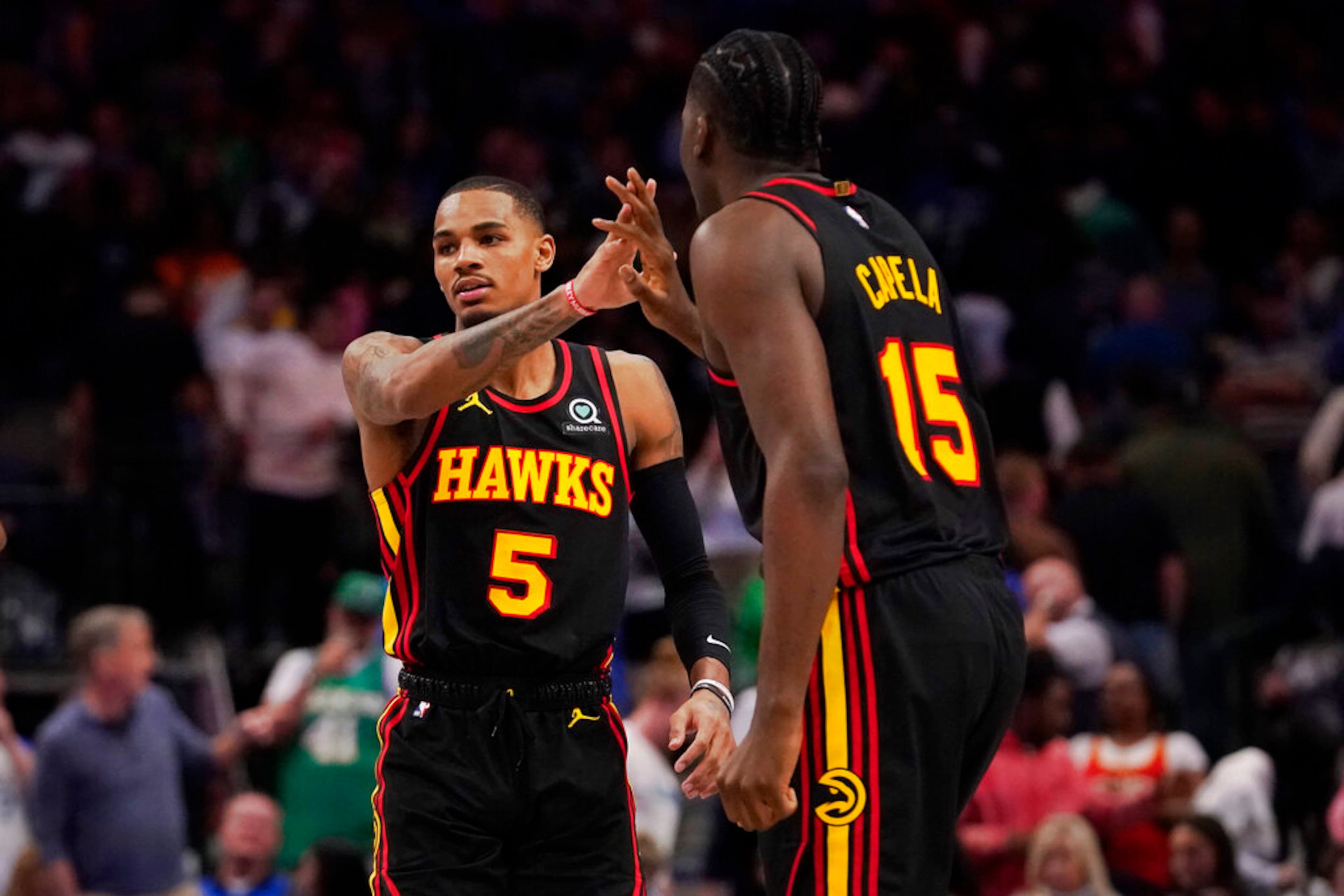 Atlanta Hawks guard Dejounte Murray (5) is congratulated by teammate Clint Capela (15) during the fourth quarter of an NBA basketball game against the Dallas Mavericks in Dallas, Wednesday, Jan. 18, 2023. Hawks won 130-122. (AP Photo/LM Otero)