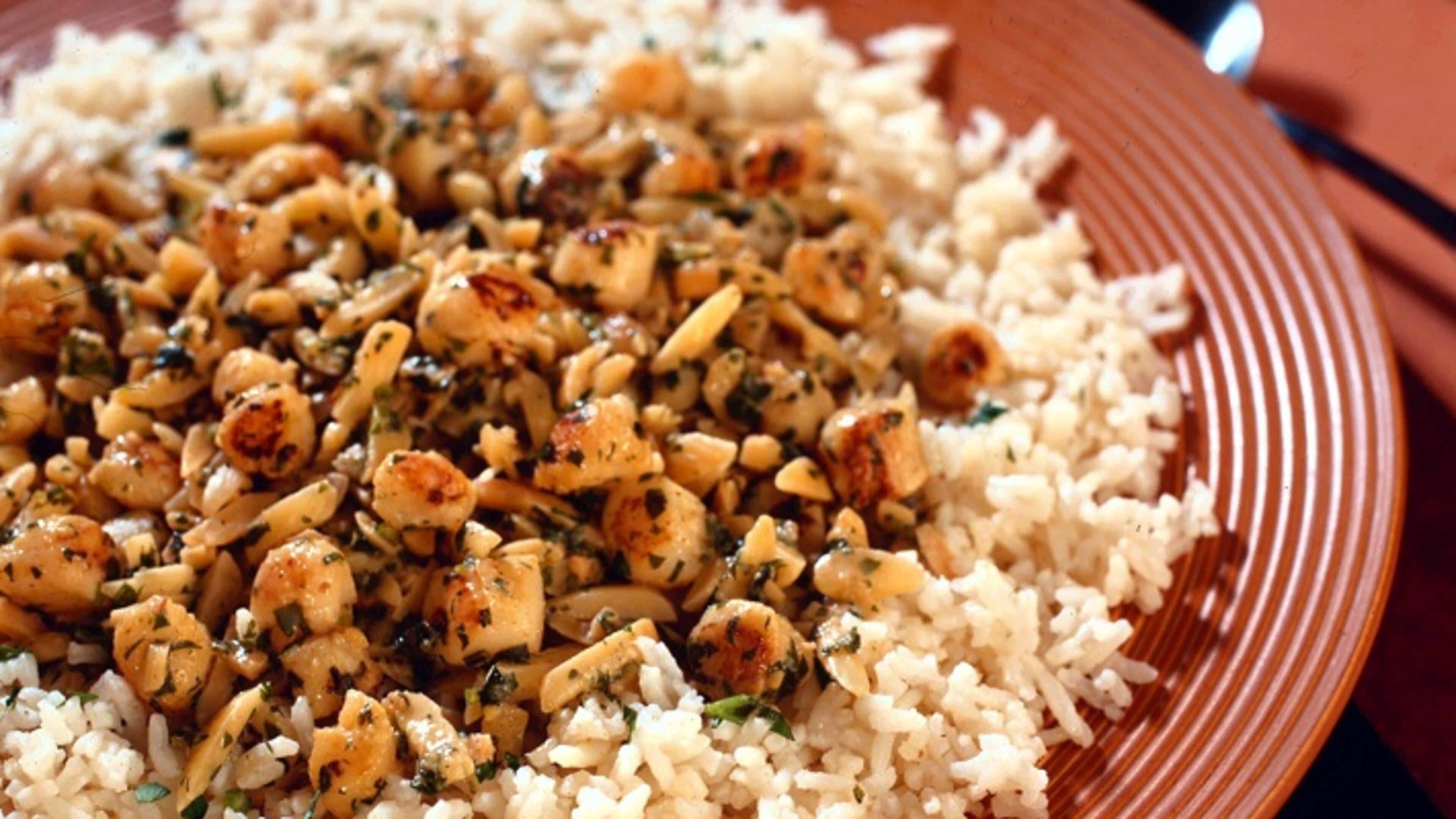 Scallops are sauteed, then mixed with lemon, almonds and garlic in a quick dinner that is yet complex and satisfying. (James F. Quinn/Chicago Tribune/TNS)