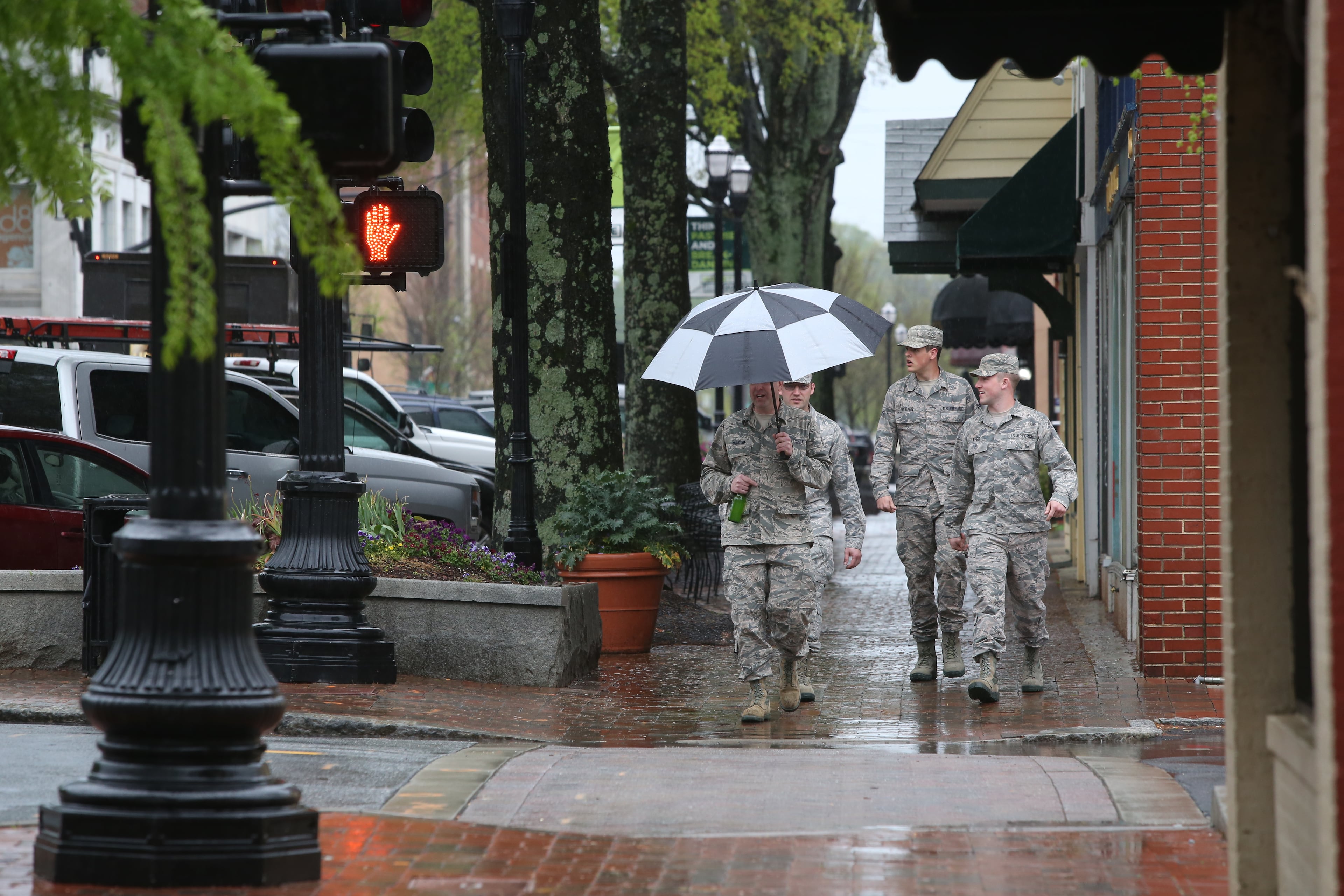 April 5, 2017, Atlanta, Georgia - Army officers walk down West Park Square against the rain, only one being equipped with an umbrella, in Marietta, Georgia, on April 5, 2017. (HENRY TAYLOR / HENRY.TAYLOR@AJC.COM)