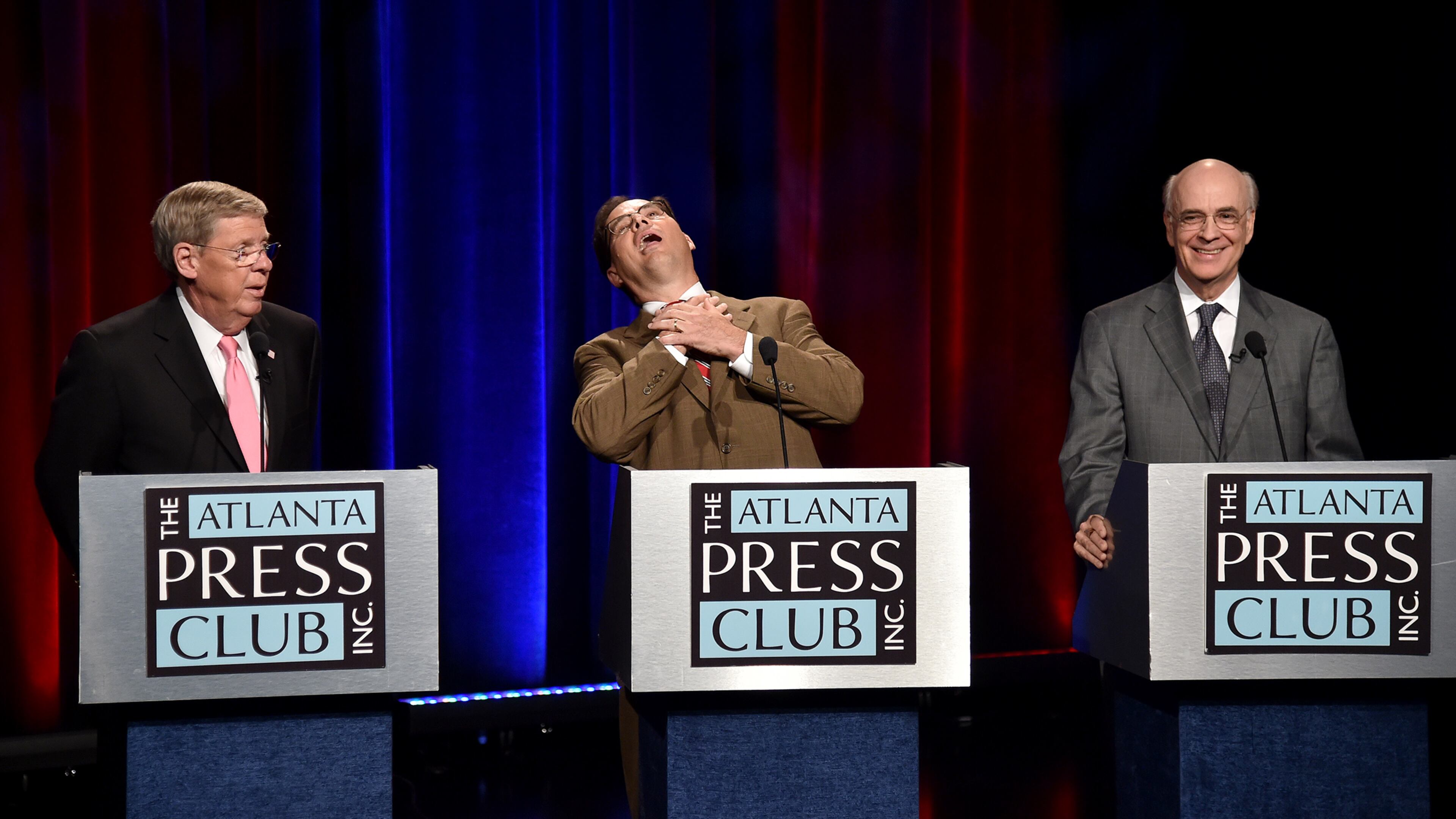 Libertarian Allen Buckley makes a choking motion during a Senate debate with incumbent U.S. Sen. Republican Johnny Isakson, left, and Democrat Jim Barksdale, right, on Friday at Georgia Public Broadcasting. Brant Sanderlin, bsanderlin@ajc.com