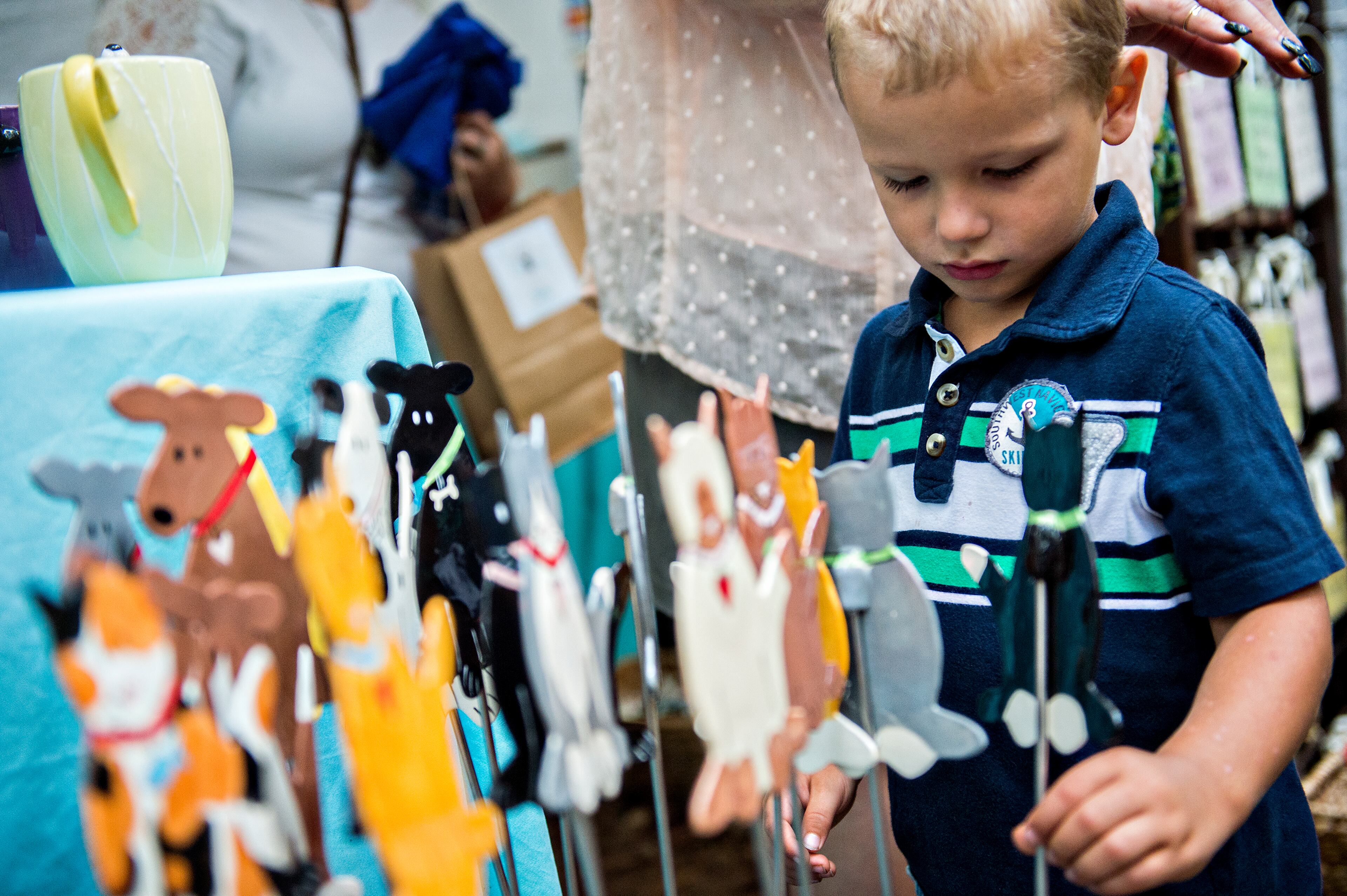 September 12, 2015 Stone Mountain - Ryley Jordan checks out a cat on a stick at one of the booths at the Yellow Daisy Festival at Stone Mountain Park on Saturday, September 12, 2015. In its 47th year, the festival features more than 400 artists from all over the country over four days. JONATHAN PHILLIPS / SPECIAL