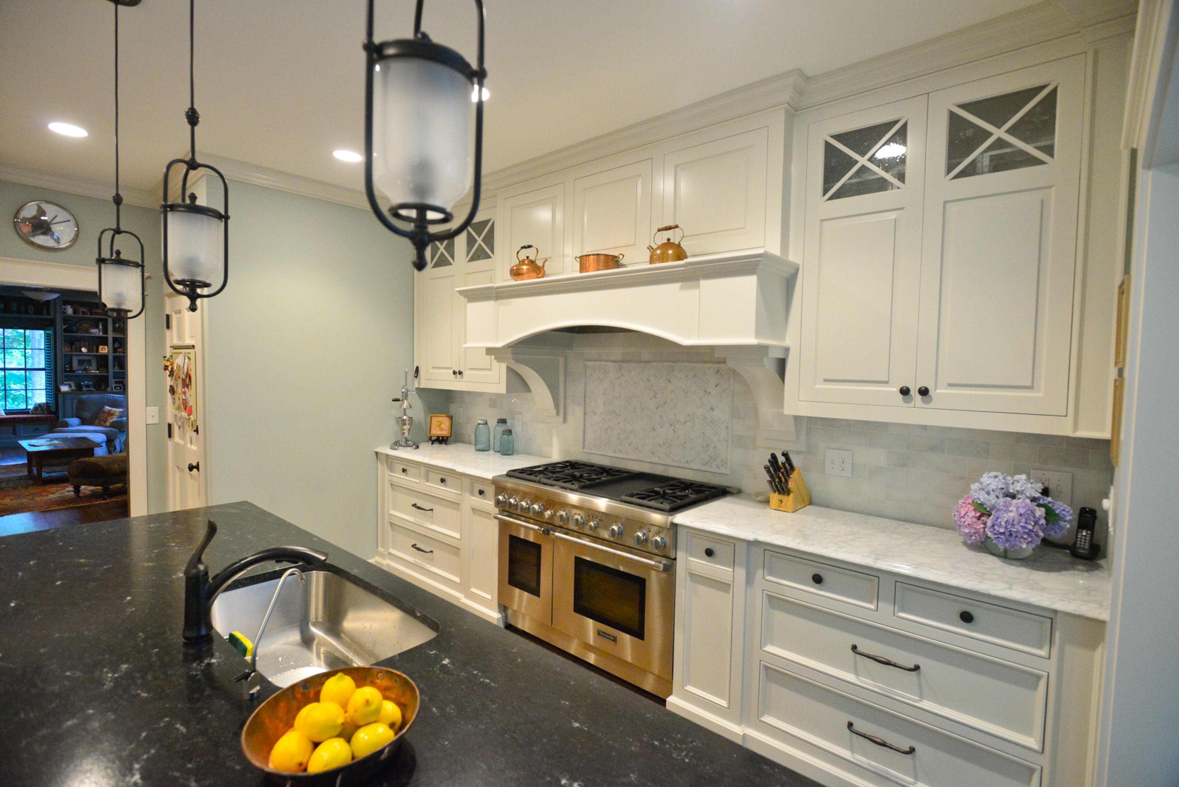 The kitchen is one of the most recent rooms to be renovated, with the homeowners bumping out the back of the home to double the size of the kitchen. Lisa Gleim-Jonas searched in showrooms and online for pendant lights that tied together the Carerra marble and black honed granite countertops, white cabinets and Tiffany light above the kitchen table, before finding the set on Overstock.com. The walls are painted Sherwin-Williams' Sea Salt.