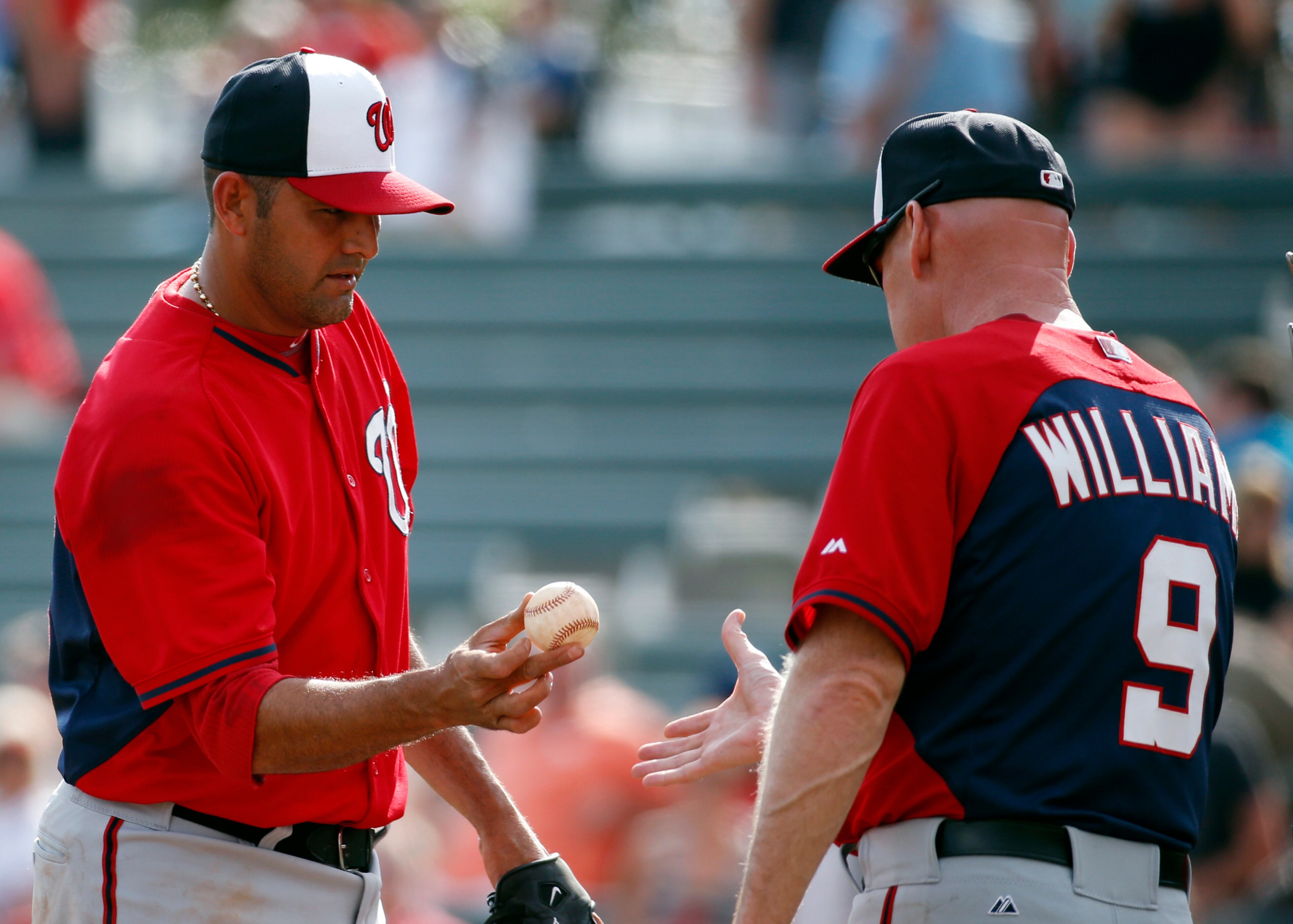 Washington Nationals relief pitcher Luis Ayala, left, is relieved by manager Matt Williams in the eighth inning of an exhibition baseball game against the Atlanta Braves, Tuesday, March 4, 2014, in Kissimmee, Fla. The Braves won 8-4.