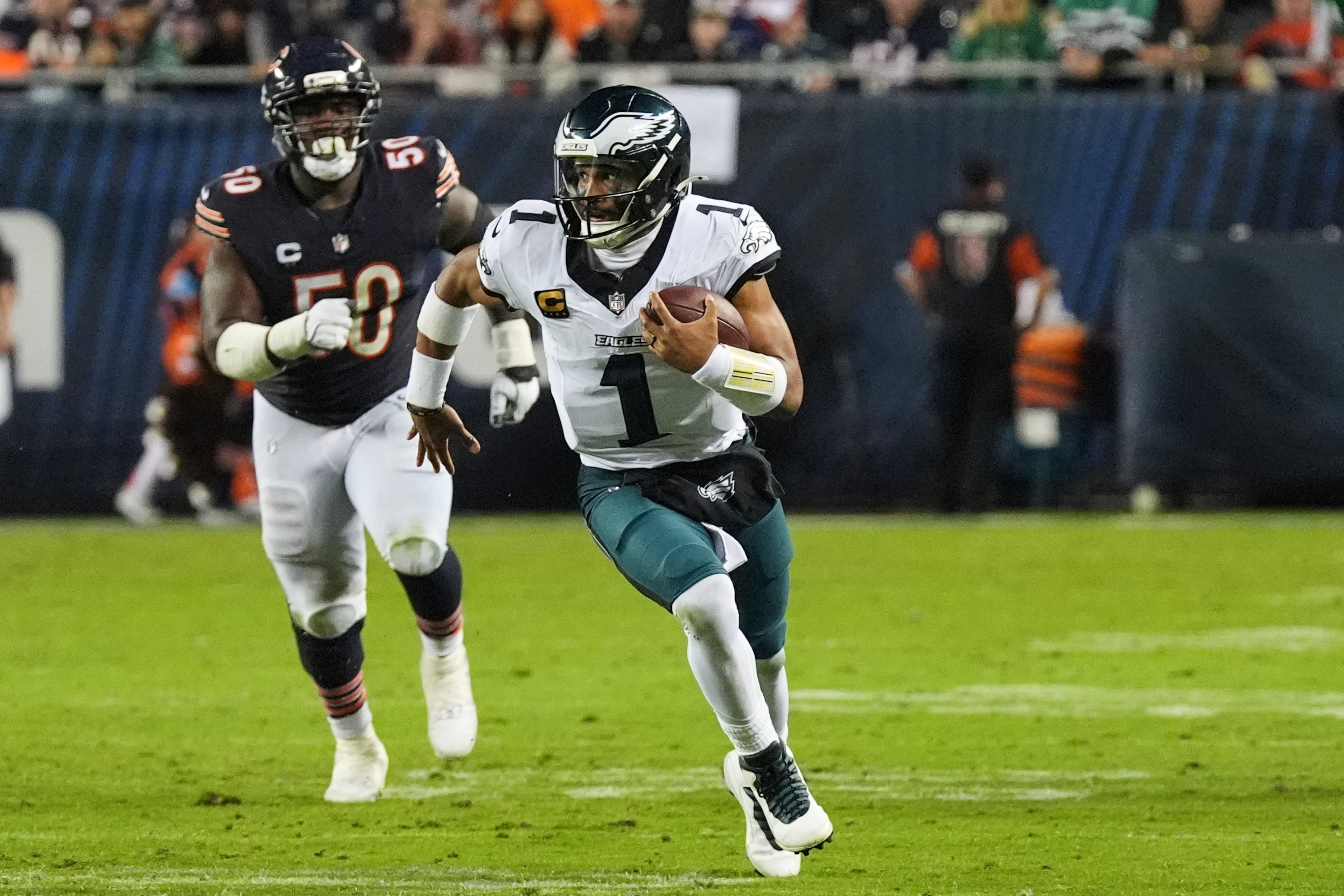 Philadelphia Eagles quarterback Jalen Hurts (1) runs the ball as Chicago Bears defensive end Grady Jarrett (50) gives chase during the second half of an NFL football game in Chicago, Monday, Sept. 28, 2026. (AP Photo/David Banks)