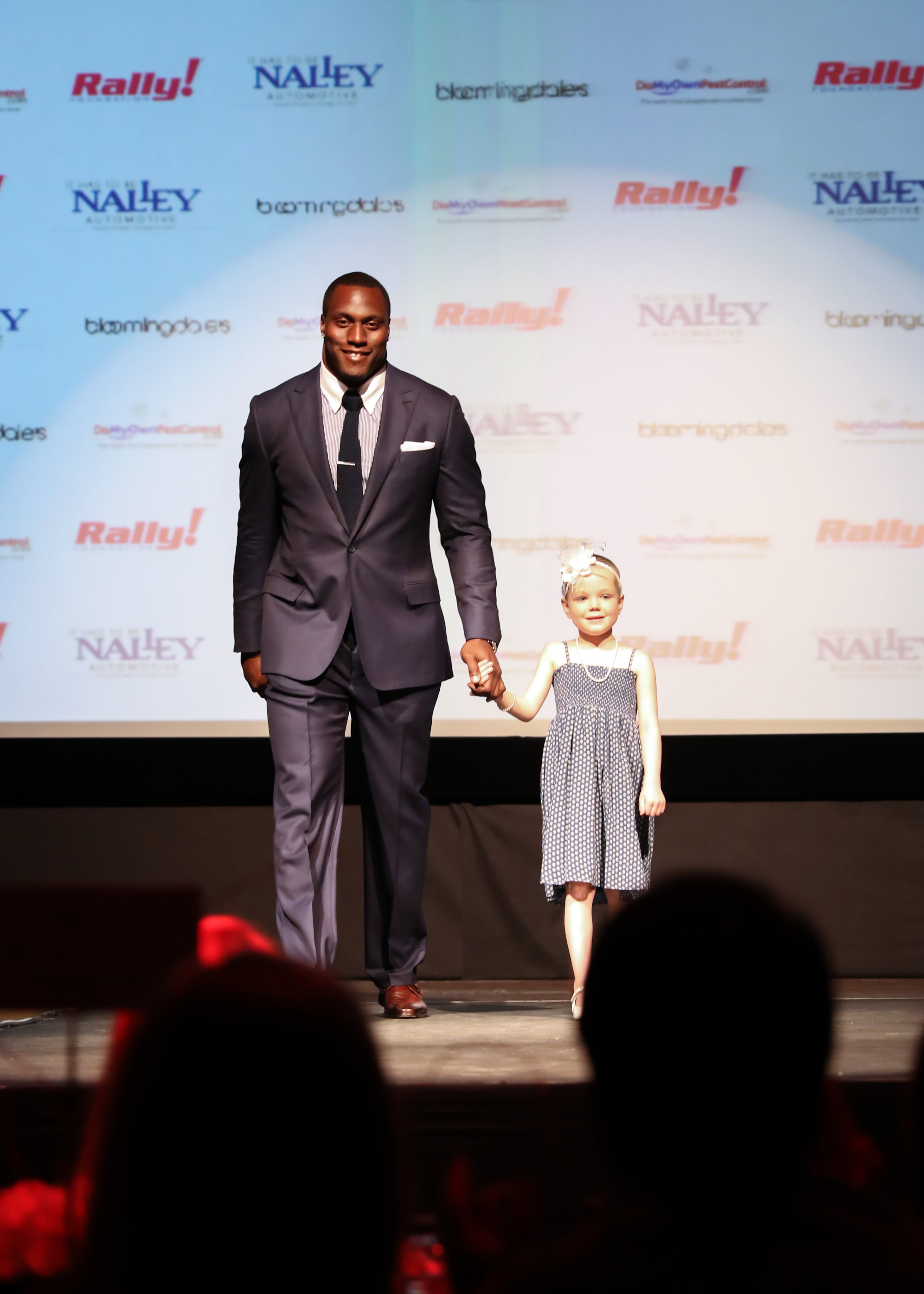 Former NFL linebacker Takeo Spikes escorts Ellanor in the 6th annual Rally on the Runway fashion show at the Buckhead Theatre on Friday, April 24, 5015. The event helped raise $200,000 for the Rally Foundation for Childhood Cancer Research. Photography by Lauren Chambers
